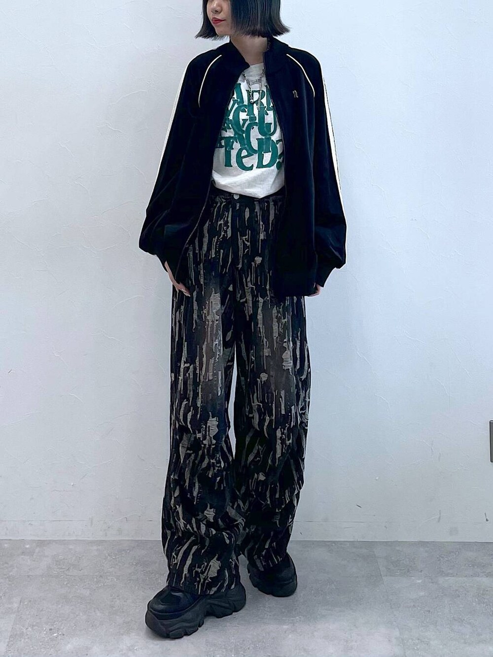 ブラック系のスニーカー、ブラック系のデニムパンツ、ブラック系のジャージを着用したレディースの秋コーディネートの6枚目の写真