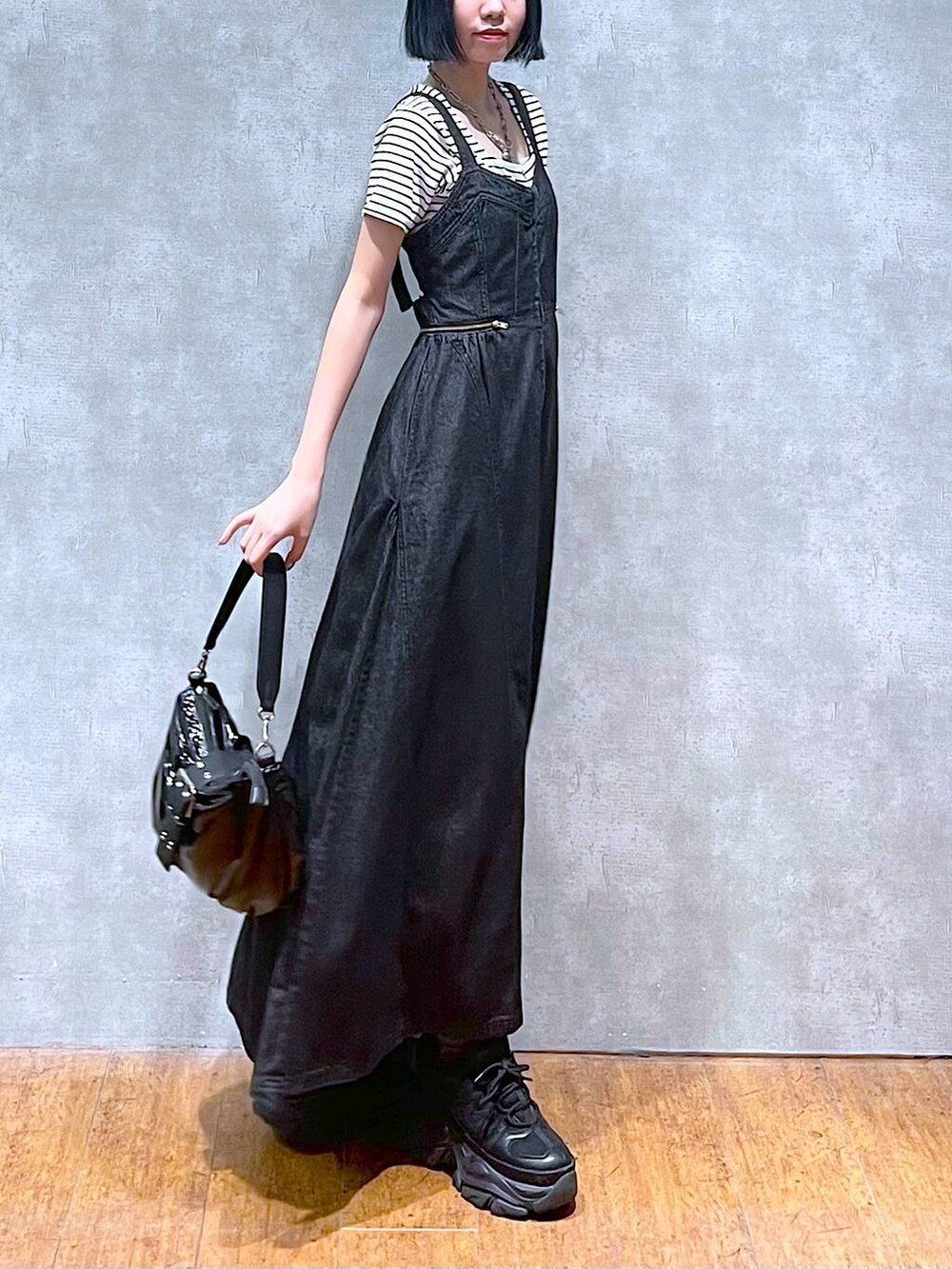 ブラック系のスニーカー、ブラック系のワンピース、ホワイト系のTシャツ/カットソーを着用したレディースの夏コーディネートの4枚目の写真