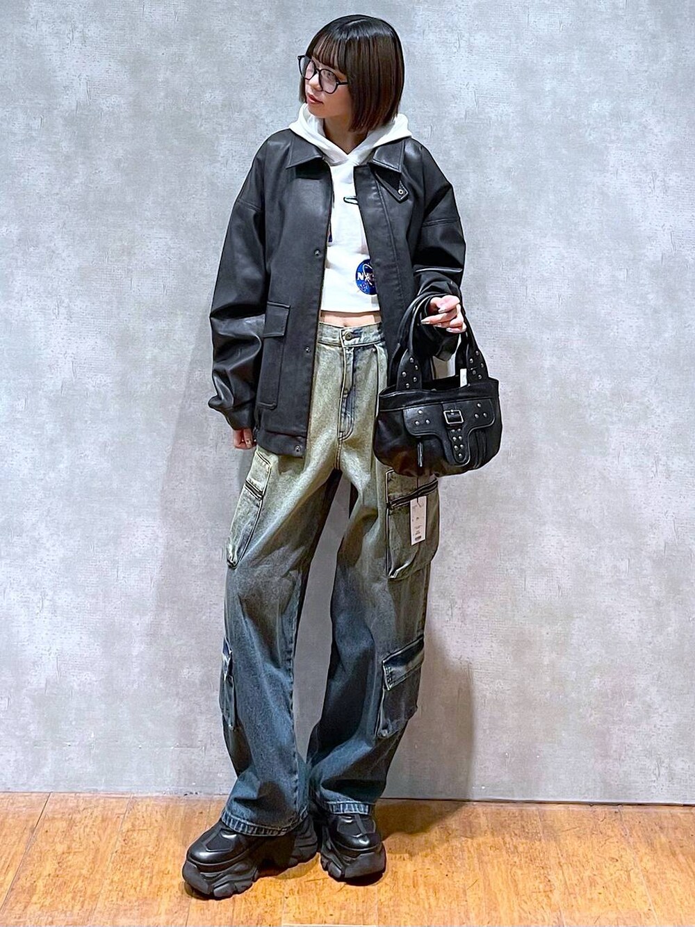 ブラック系のスニーカー、ブラック系のブルゾン、ブルー系のデニムパンツを着用したレディースの秋コーディネートの6枚目の写真