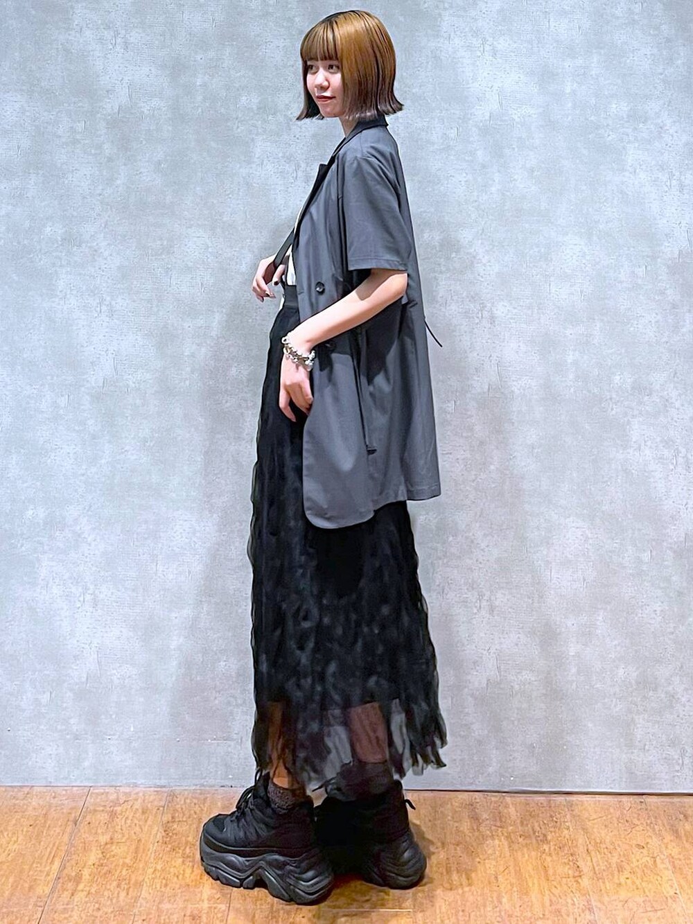 ブラック系のスニーカー、グレー系のテーラードジャケット、ホワイト系のTシャツ/カットソーを着用したレディースの夏コーディネートの4枚目の写真