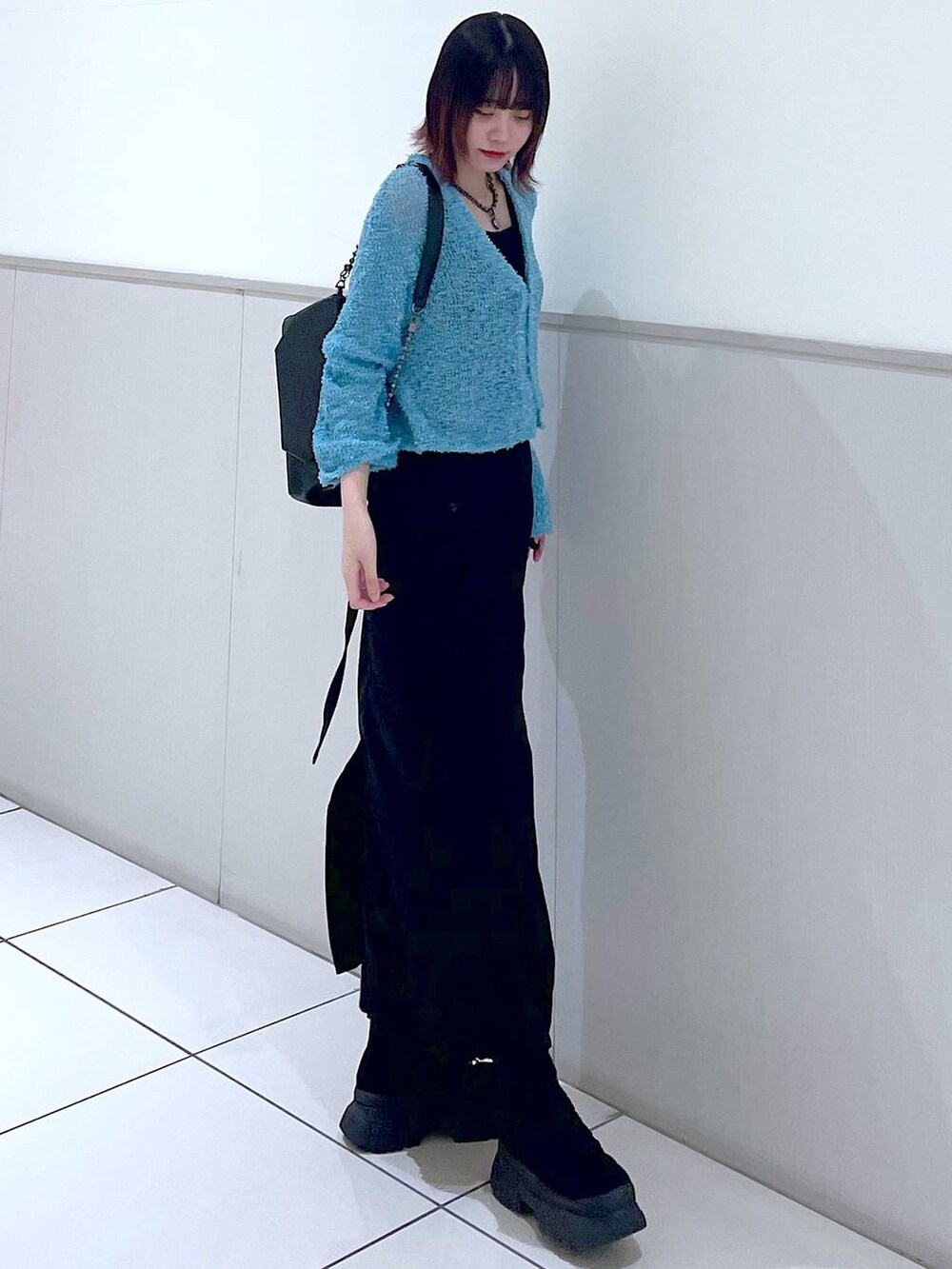 ブラック系のショルダーバッグ、ブラック系のタンクトップ、ブラック系のブーツを着用したレディースの春コーディネートの2枚目の写真