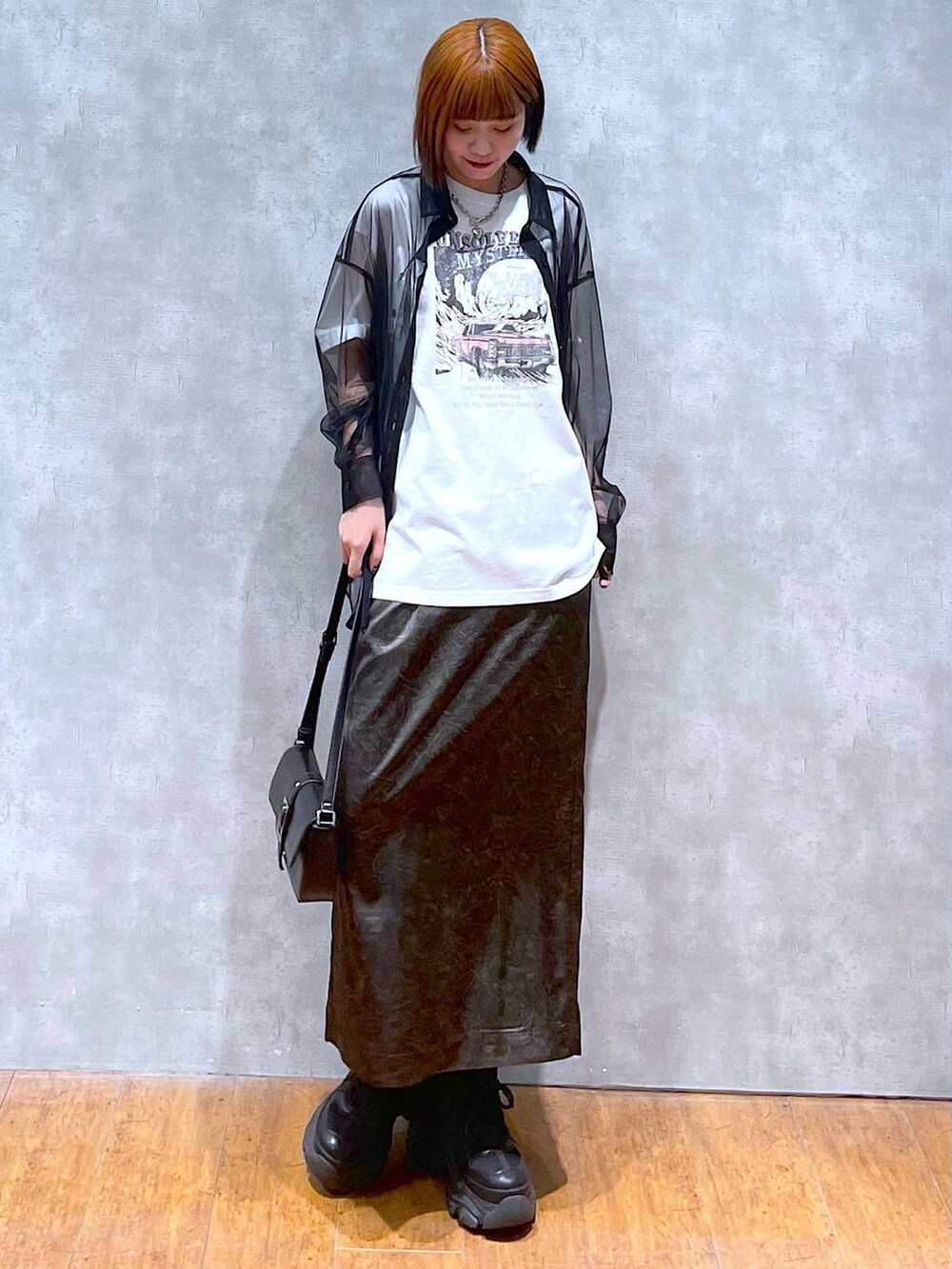 ブラック系のスニーカー、ホワイト系のTシャツ/カットソー、ブラック系のハンドバッグを着用したレディースの夏コーディネートの3枚目の写真