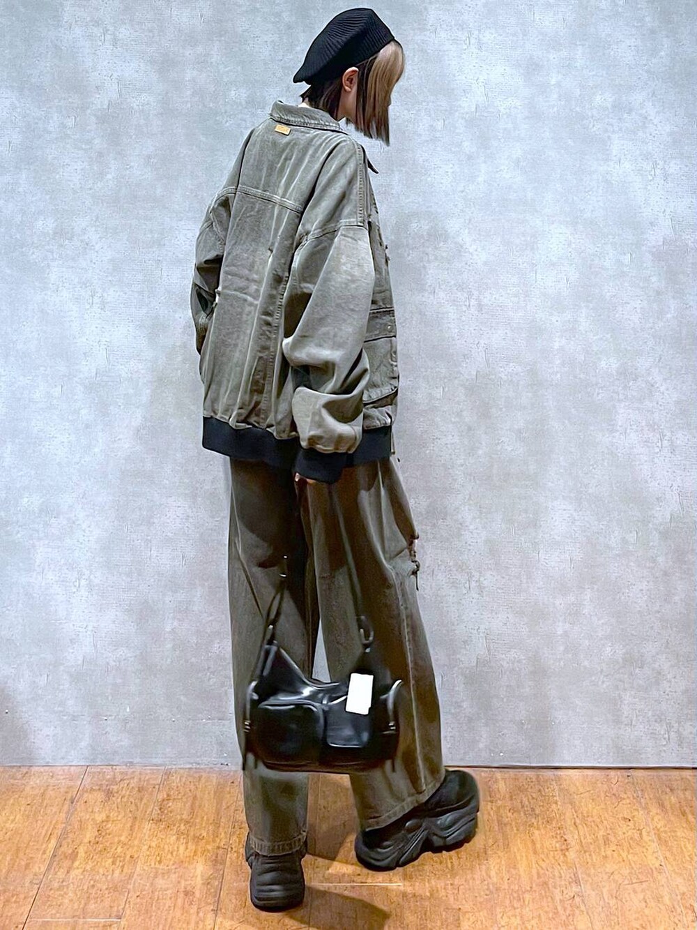 ブラック系のスニーカー、ブラック系のTシャツ/カットソー、ブラック系のブルゾンを着用したレディースの秋コーディネートの4枚目の写真