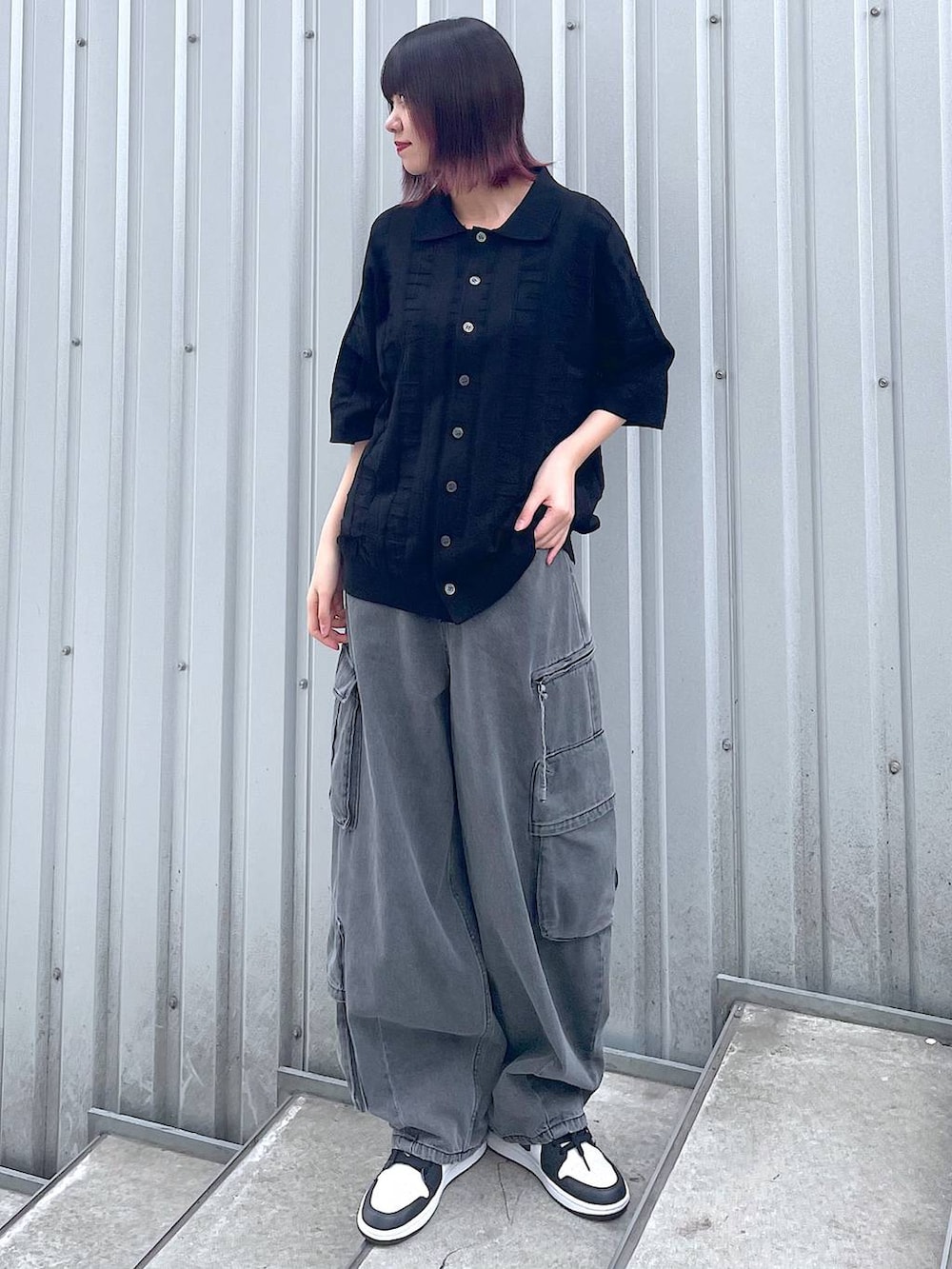 ブラック系のニット/セーター、ブラック系のデニムパンツ、ブラック系のベルトを着用したレディースの春コーディネートの5枚目の写真