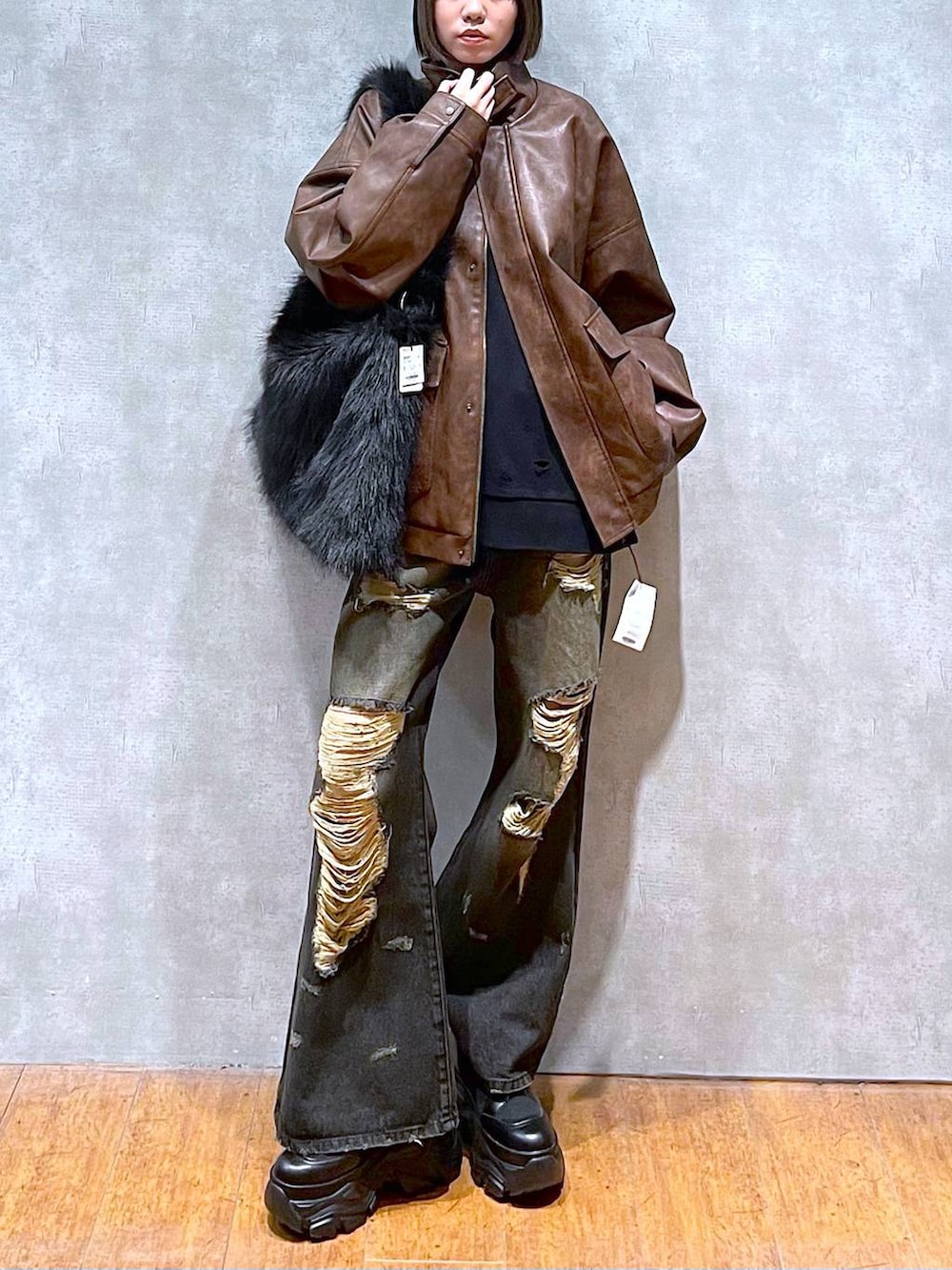 ブラウン系のブルゾン、ブラック系のブーツ、グレー系のスウェットを着用したレディースの秋コーディネートの7枚目の写真