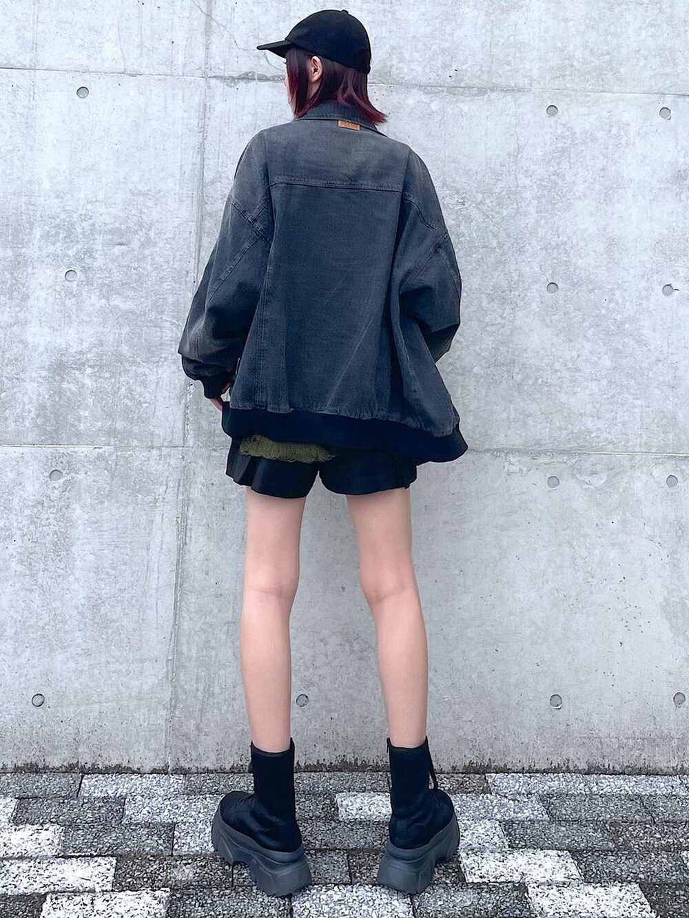 ブラック系のデニムジャケット、グリーン系のニット/セーター、ブラック系のその他パンツを着用したレディースの春コーディネートの6枚目の写真