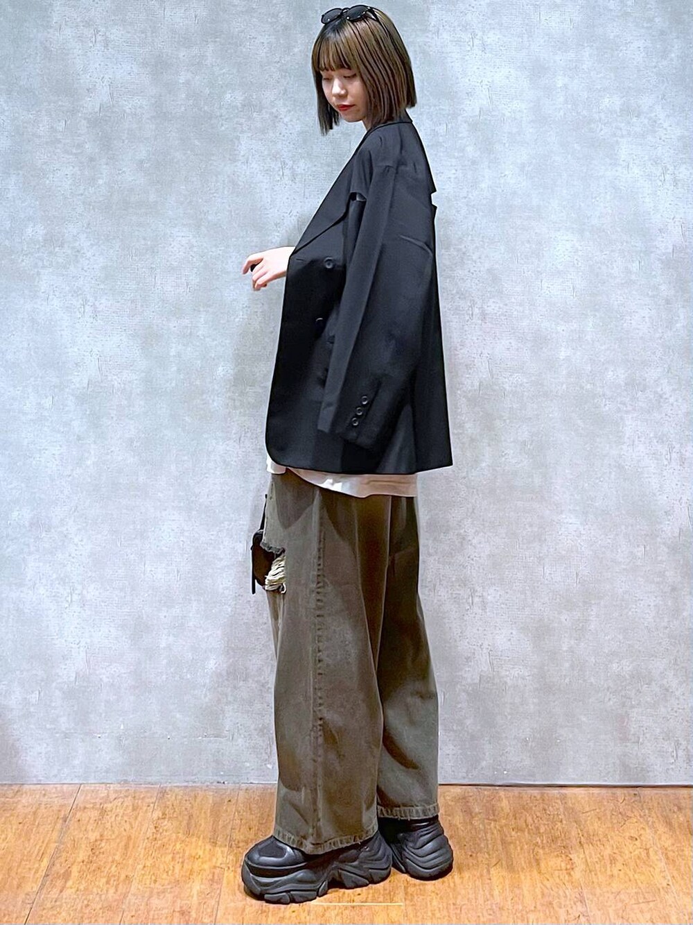 ブラック系のスニーカー、ベージュ系のTシャツ/カットソー、ブラック系のデニムパンツを着用したレディースの秋コーディネートの3枚目の写真