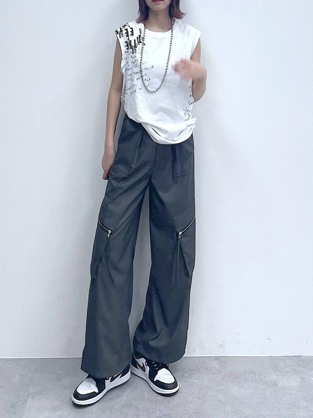 グレー系のスラックス、ホワイト系のTシャツ/カットソー、シルバー系のネックレスを着用したレディースの夏コーディネートの3枚目の写真