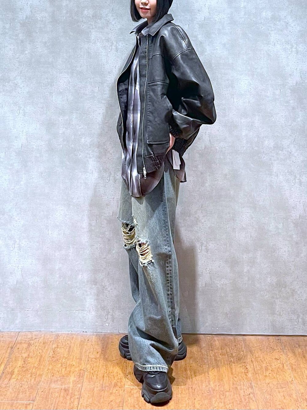 ブラック系のスニーカー、グレー系のシャツ/ブラウス、ブルー系のデニムパンツを着用したレディースの秋コーディネートの2枚目の写真