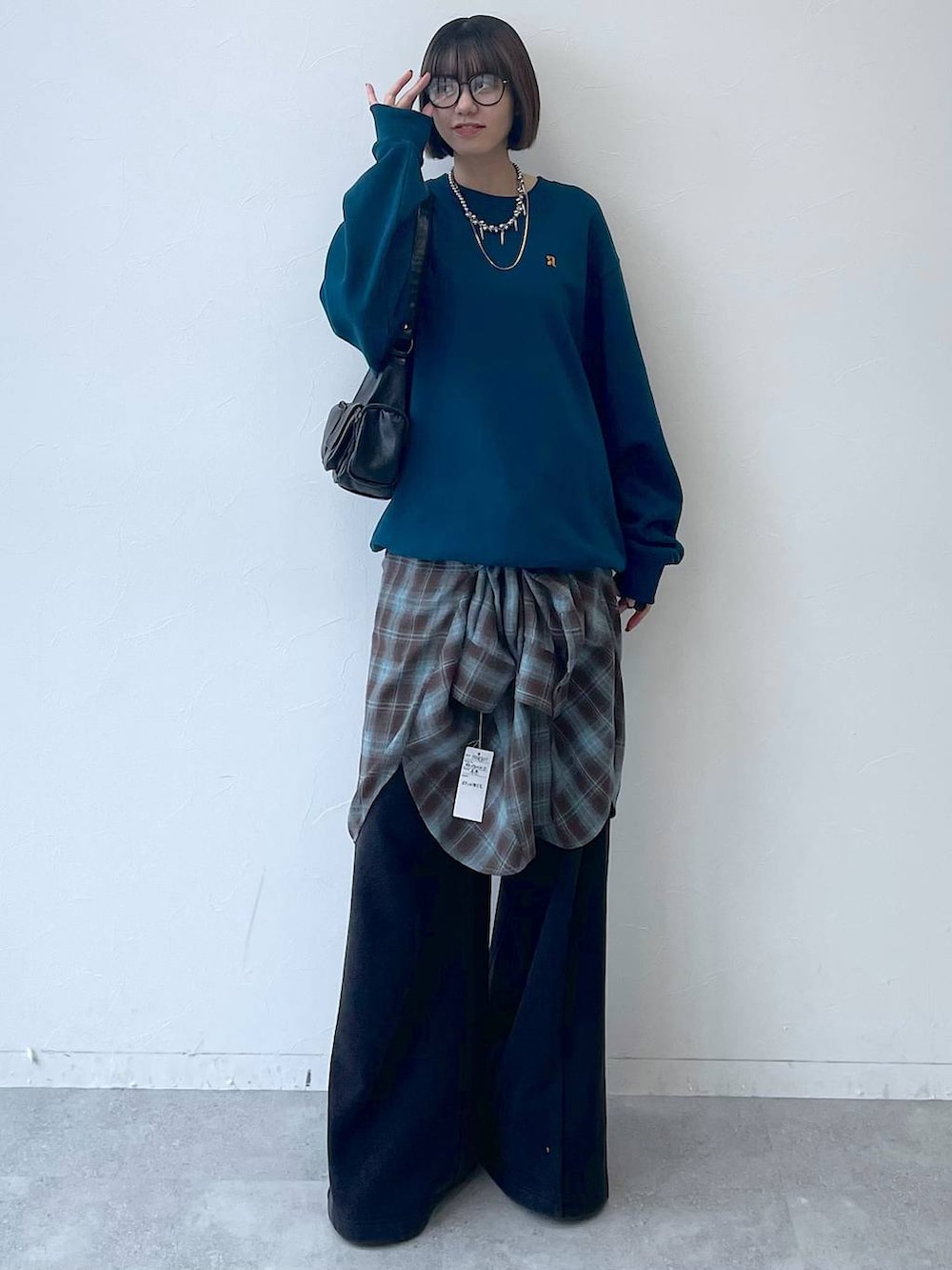 ブラック系のスニーカー、ブラック系のショルダーバッグ、グリーン系のスウェットを着用したレディースの秋コーディネートの9枚目の写真