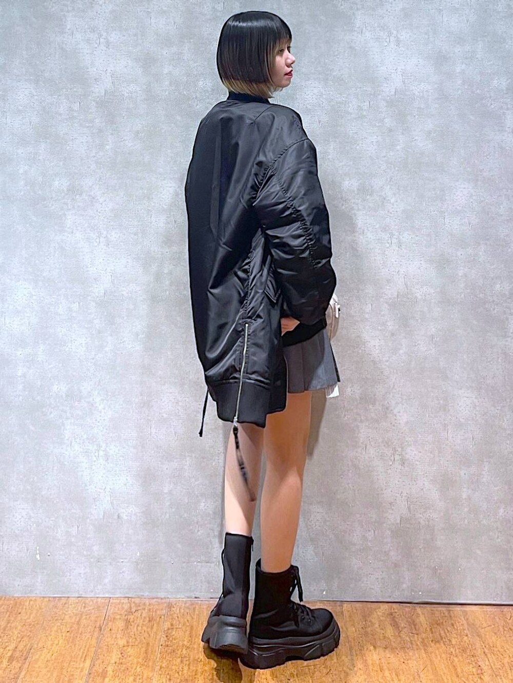 ブラック系のMA-1、ブラック系のブーツ、ブラック系のニット/セーターを着用したレディースの冬コーディネートの5枚目の写真