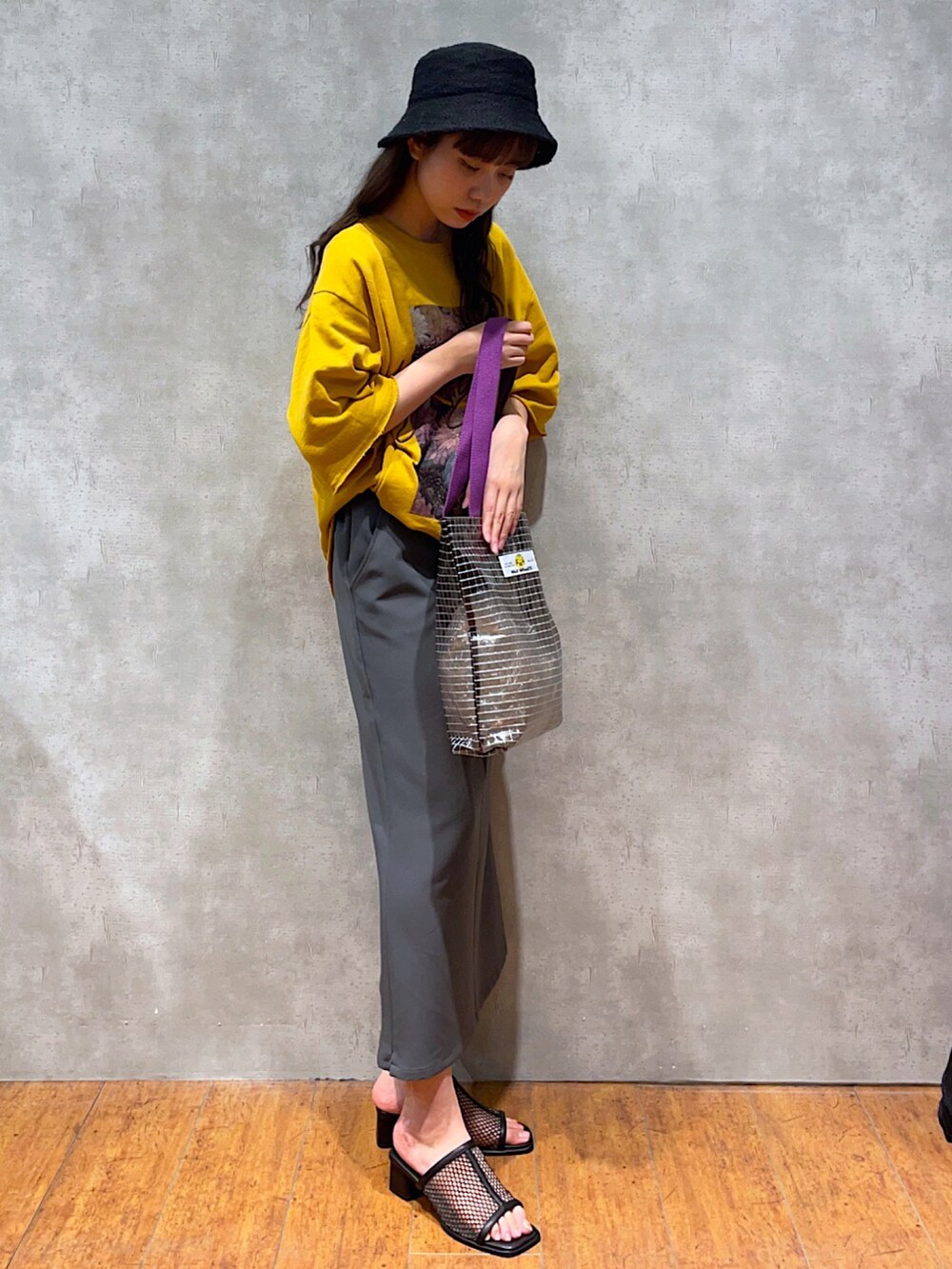 イエロー系のTシャツ/カットソー、グリーン系のトートバッグ、グレー系のスカートを着用したレディースの夏コーディネートの2枚目の写真