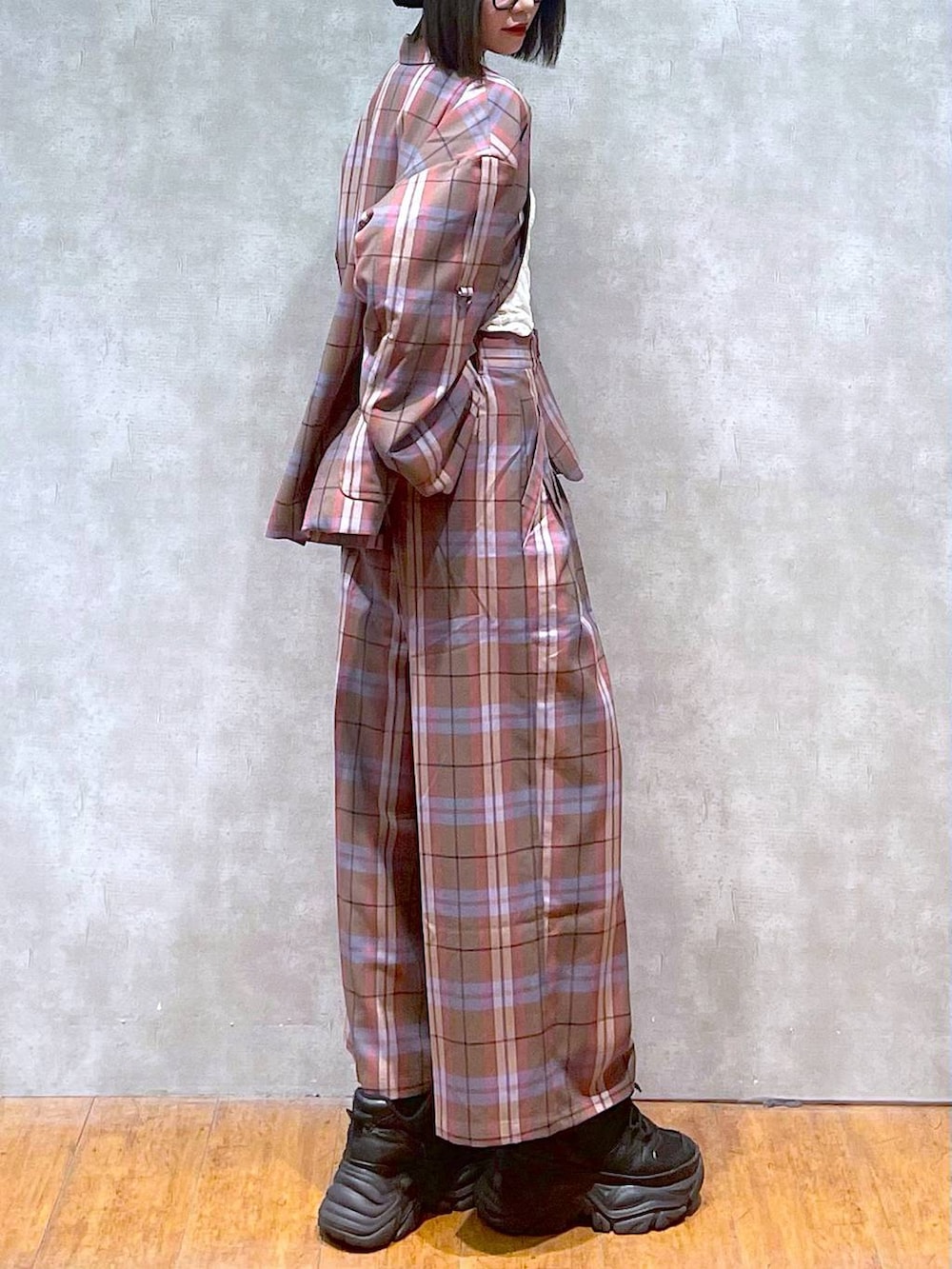 ブラック系のスニーカー、ブラウン系のテーラードジャケット、ブラウン系のスラックスを着用したレディースの秋コーディネートの5枚目の写真