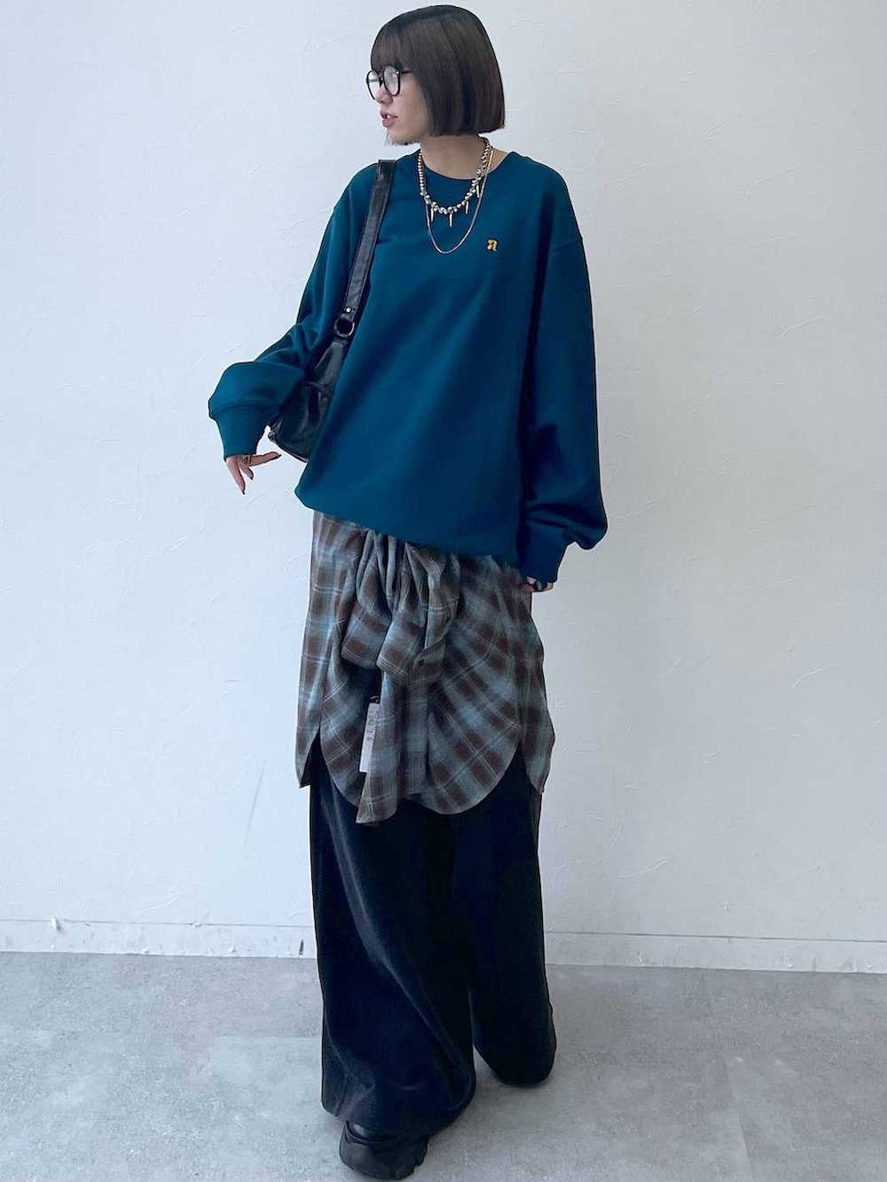 ブラック系のスニーカー、ブラック系のショルダーバッグ、グリーン系のスウェットを着用したレディースの秋コーディネートの3枚目の写真