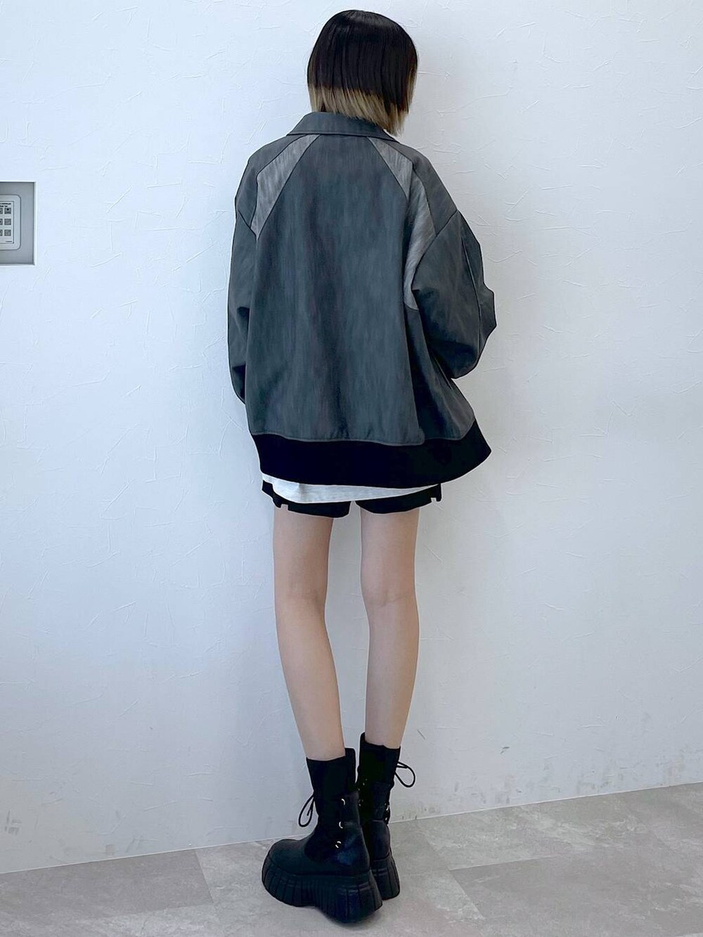 グレー系のブルゾン、ブラック系のその他パンツ、ブラック系のブーツを着用したレディースの冬コーディネートの5枚目の写真