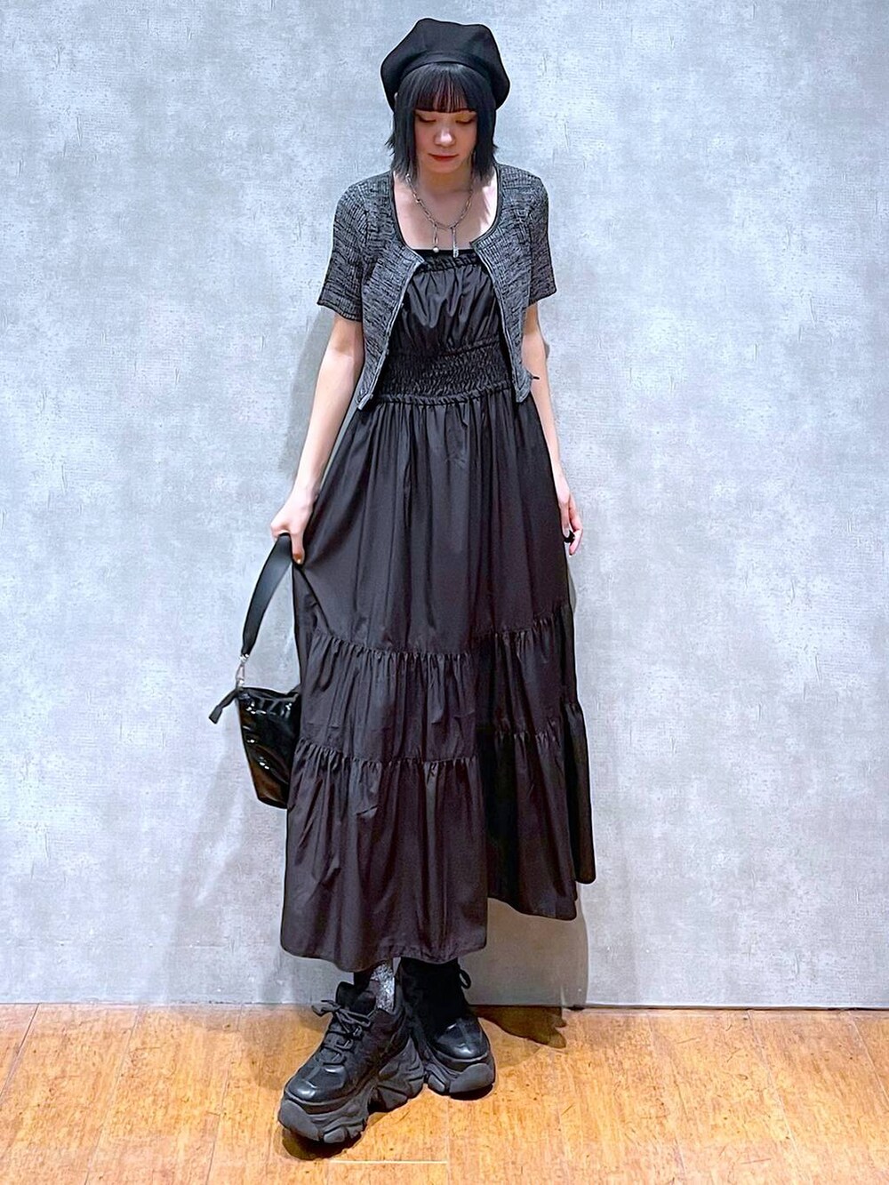 ブラック系のスニーカー、ブラック系のショルダーバッグ、ブラック系のワンピースを着用したレディースの夏コーディネートの7枚目の写真