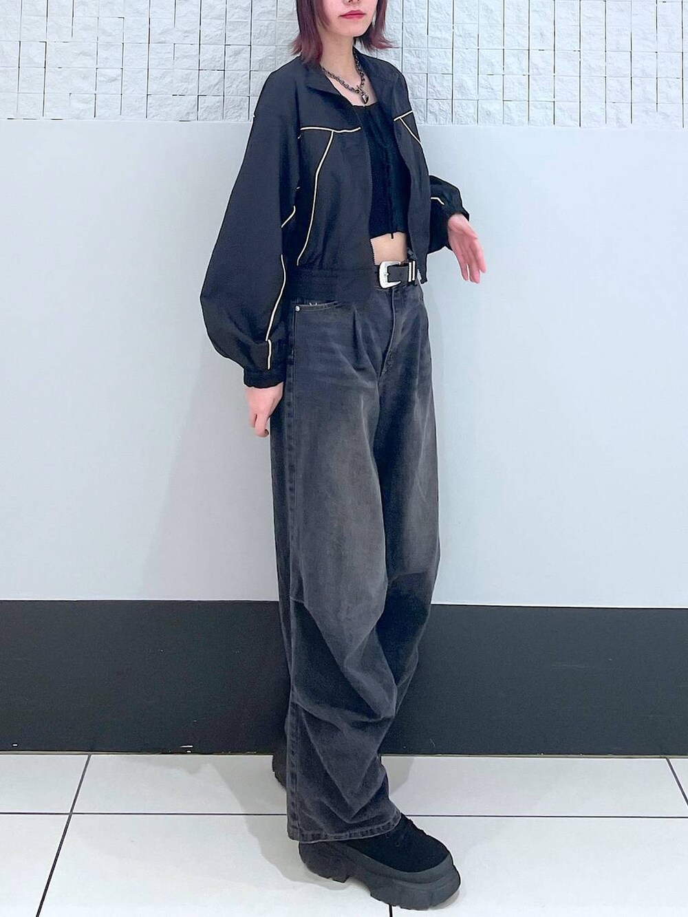 ブラック系のブルゾン、ブラック系のデニムパンツ、ブラック系のタンクトップを着用したレディースの春コーディネートの3枚目の写真