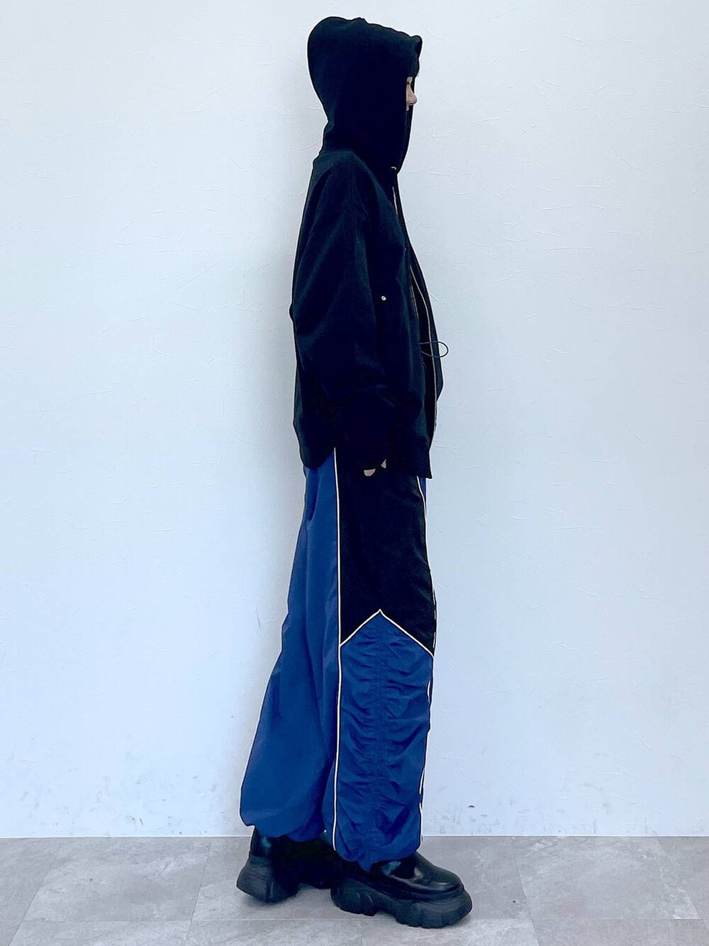 ブラック系のパーカー、ブラック系のブーツ、ブルー系のその他パンツを着用したレディースの冬コーディネートの2枚目の写真