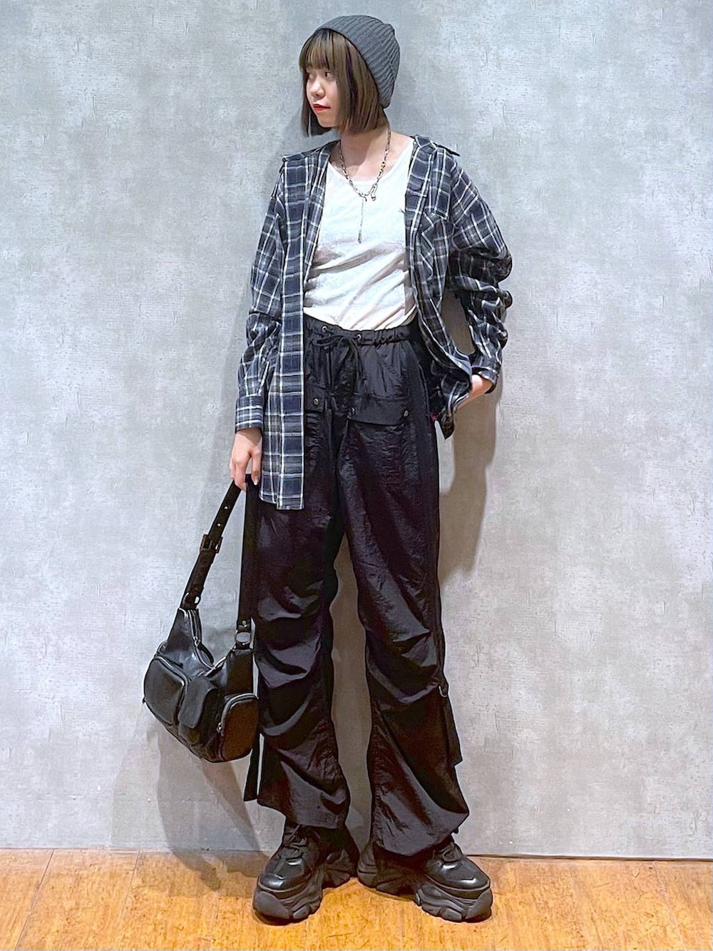 ブラック系のスニーカー、ブラック系のカーゴパンツ、ブルー系のシャツ/ブラウスを着用したレディースの秋コーディネートの4枚目の写真