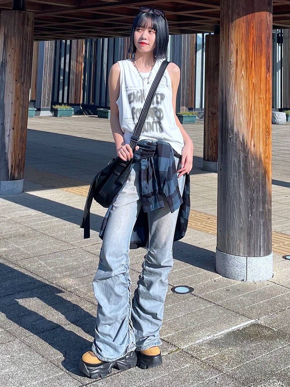 ホワイト系のTシャツ/カットソー、ブルー系のデニムパンツ、ブラウン系のブーツを着用したレディースの秋コーディネートの3枚目の写真