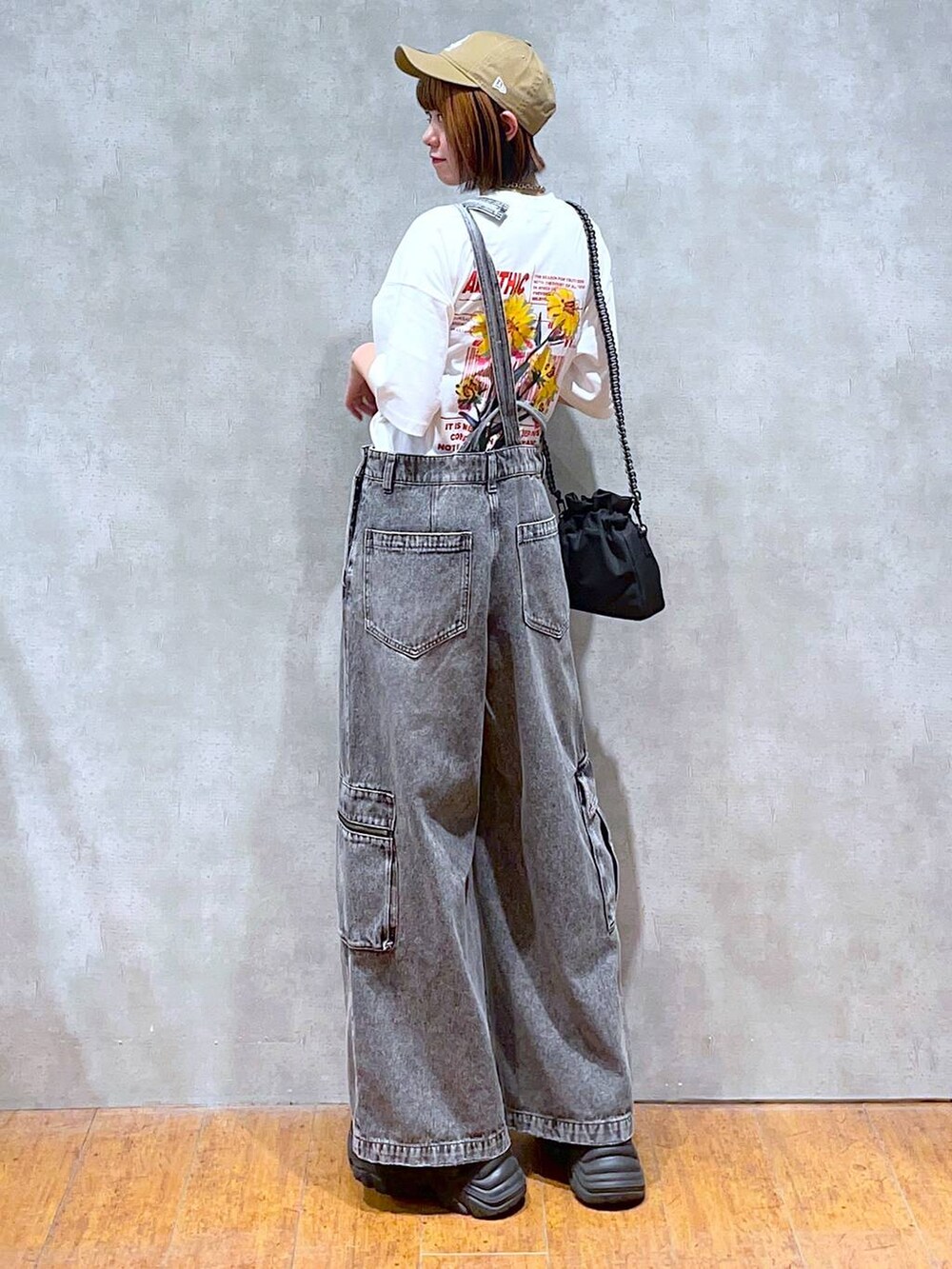 ブラック系のスニーカー、ブラック系のショルダーバッグ、ホワイト系のTシャツ/カットソーを着用したレディースの夏コーディネートの5枚目の写真