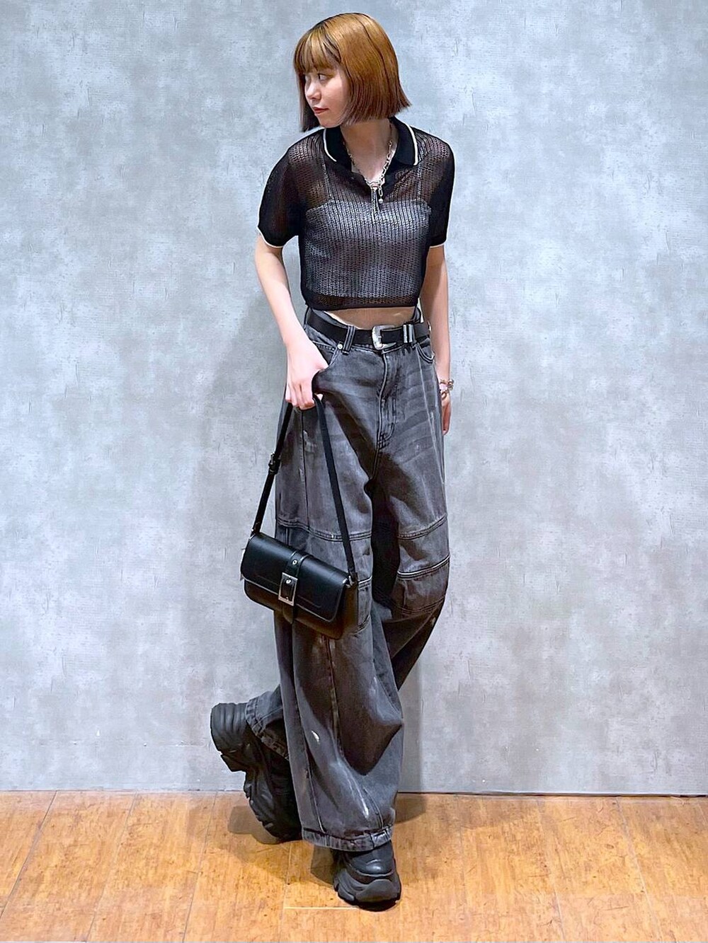 ブラック系のスニーカー、ホワイト系のキャミソール、ブラック系のデニムパンツを着用したレディースの夏コーディネートの7枚目の写真