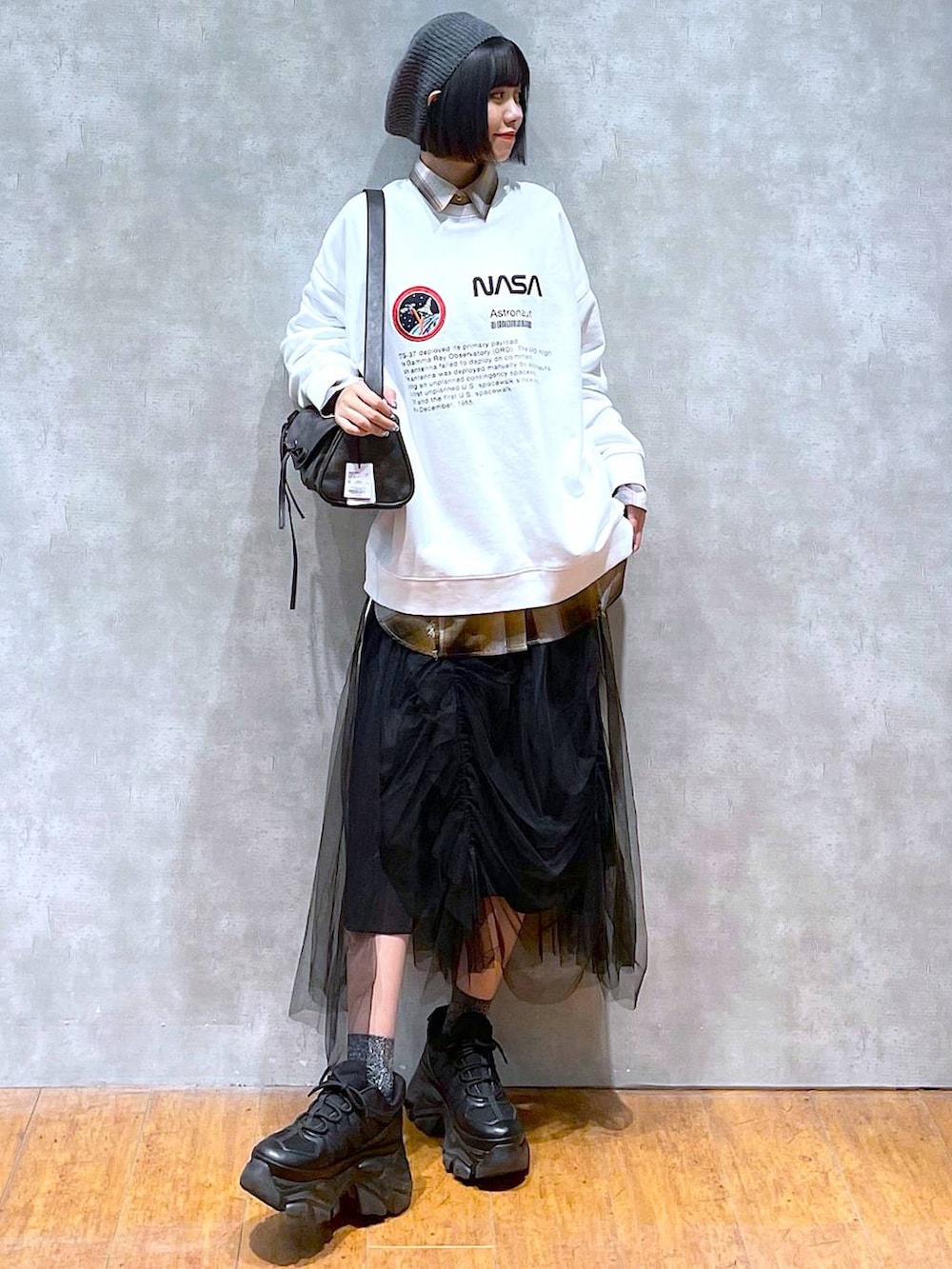 ブラック系のスニーカー、ブラック系のショルダーバッグ、ブラック系のスカートを着用したレディースの秋コーディネートの6枚目の写真