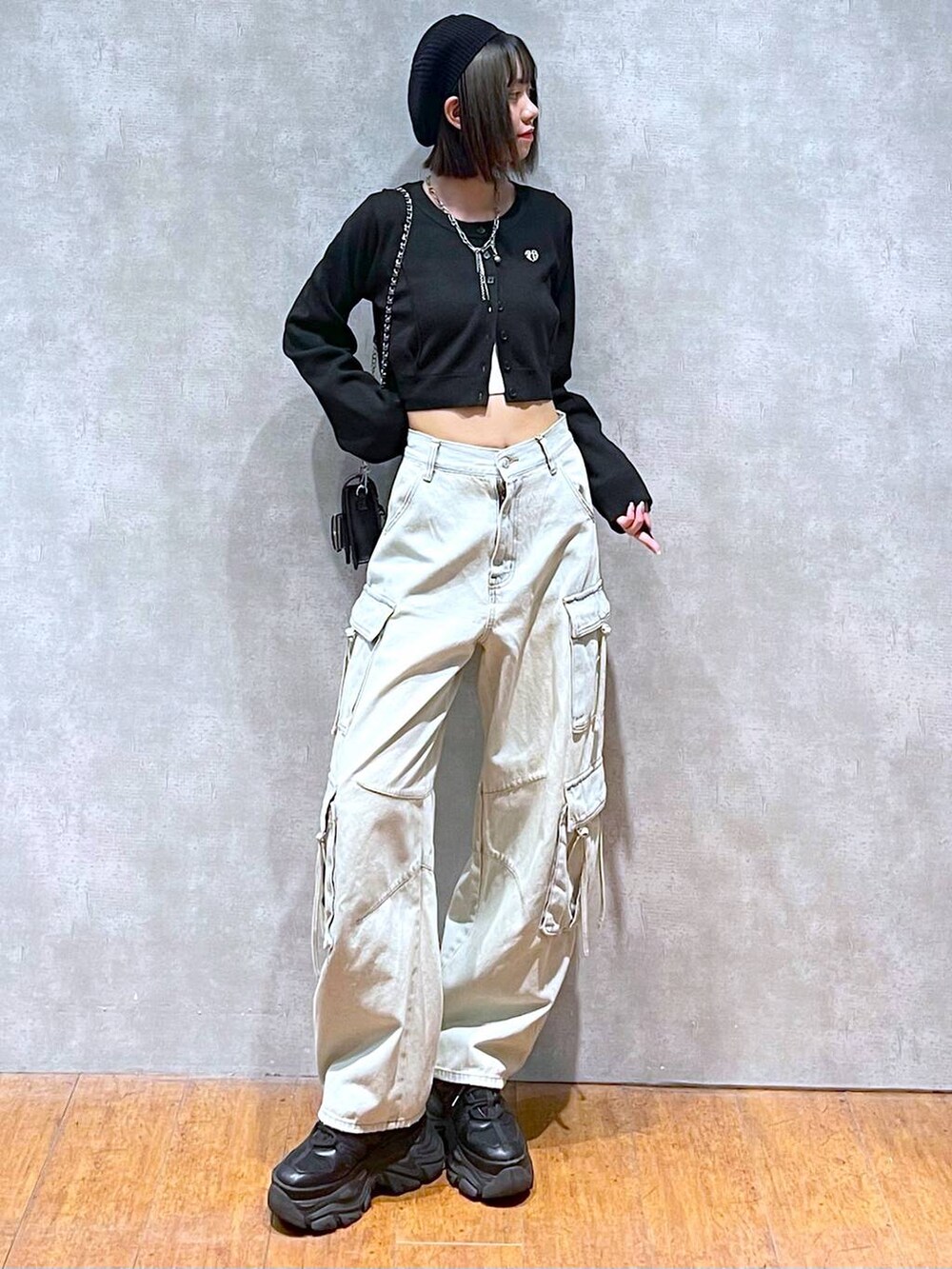 ブラック系のスニーカー、ブルー系のデニムパンツ、ブラック系のショルダーバッグを着用したレディースの秋コーディネートの7枚目の写真