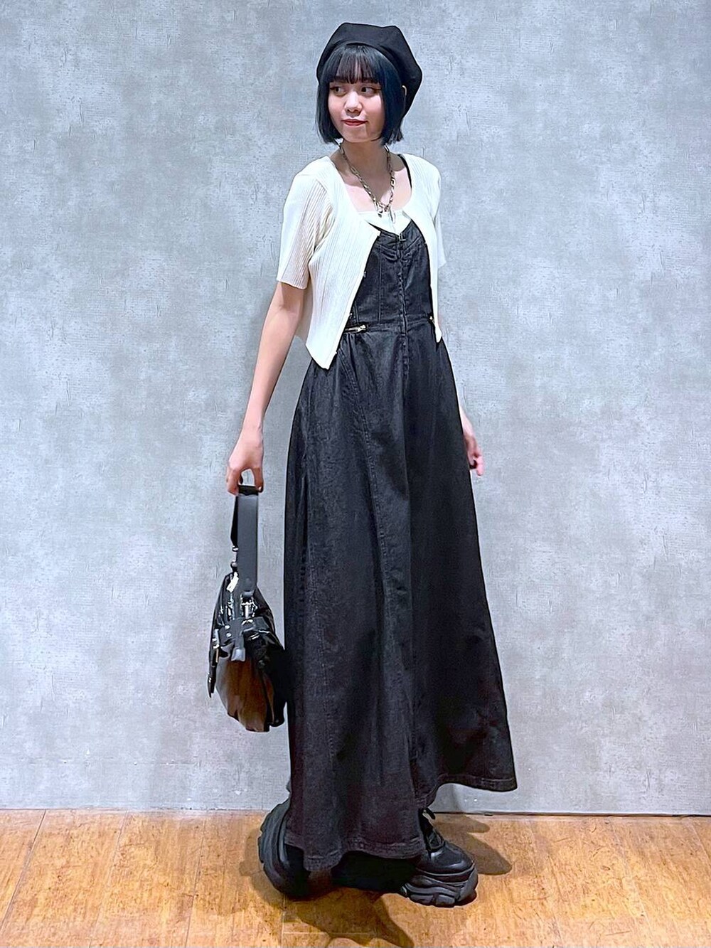 ブラック系のスニーカー、ブラック系のワンピース、ホワイト系のキャミソールを着用したレディースの夏コーディネートの2枚目の写真