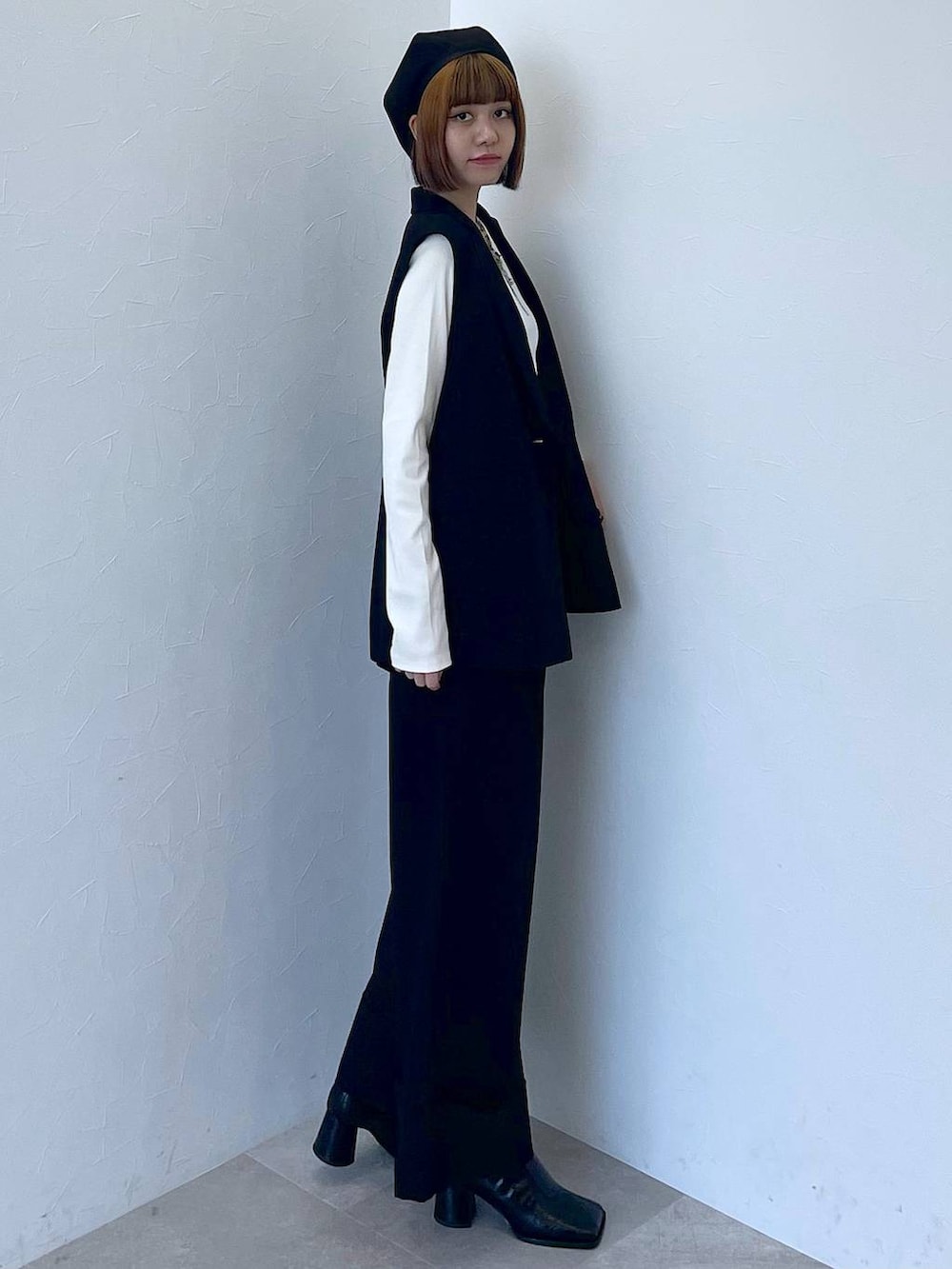 ブラック系のその他パンツ、ブラック系のベスト、ホワイト系のTシャツ/カットソーを着用したレディースの秋コーディネートの4枚目の写真