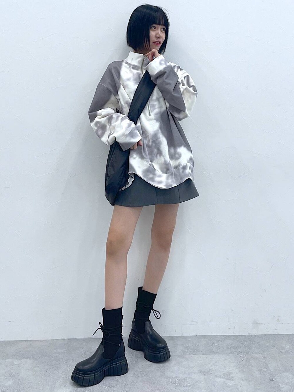 ブラック系のトートバッグ、ブラック系のブーツ、ホワイト系のTシャツ/カットソーを着用したレディースの冬コーディネートの3枚目の写真