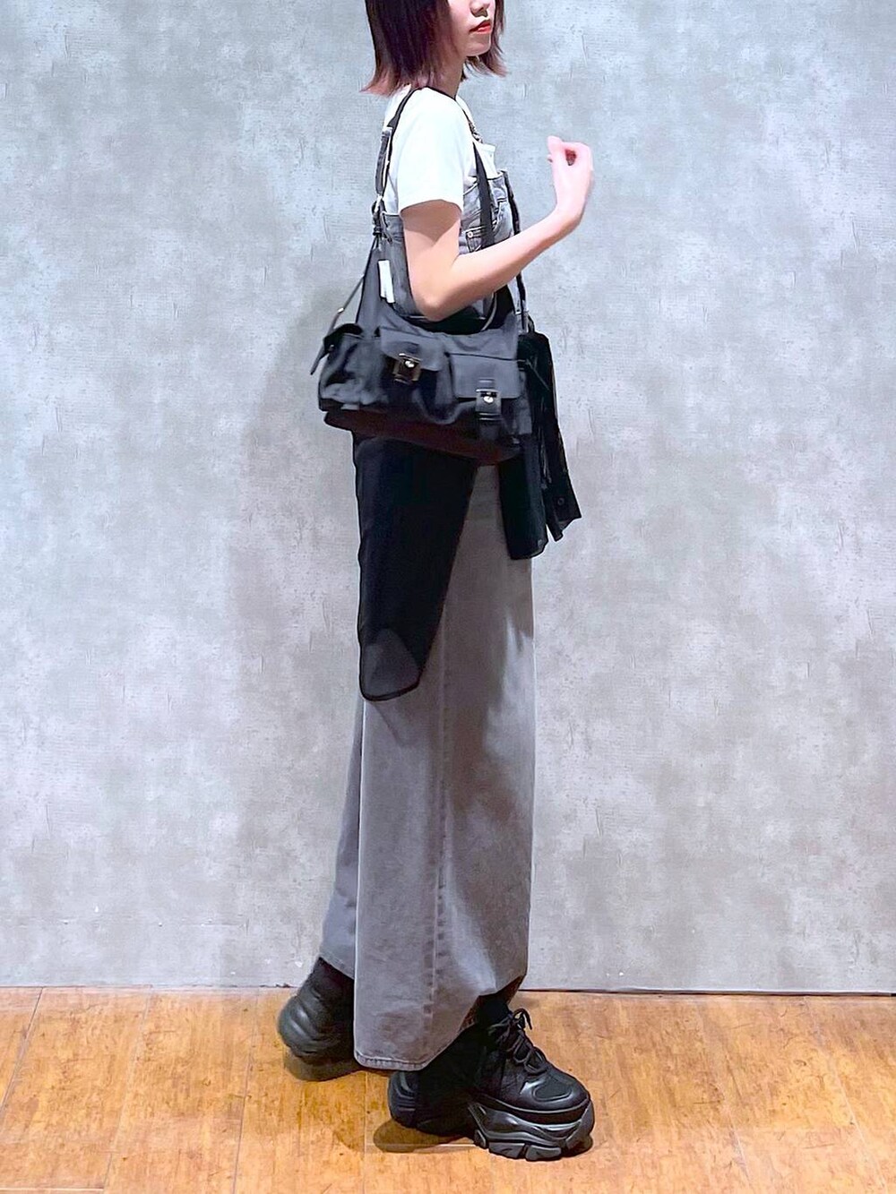 ブラック系のショルダーバッグ、ブラック系のサロペット/オーバーオール、ブラック系のスニーカーを着用したレディースの春コーディネートの5枚目の写真