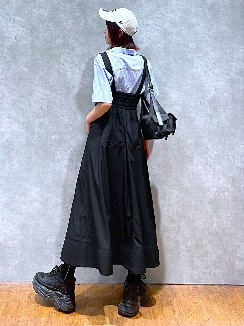 ブラック系のショルダーバッグ、ブラック系のスニーカー、ブラック系のスカートを着用したレディースの春コーディネートの5枚目の写真