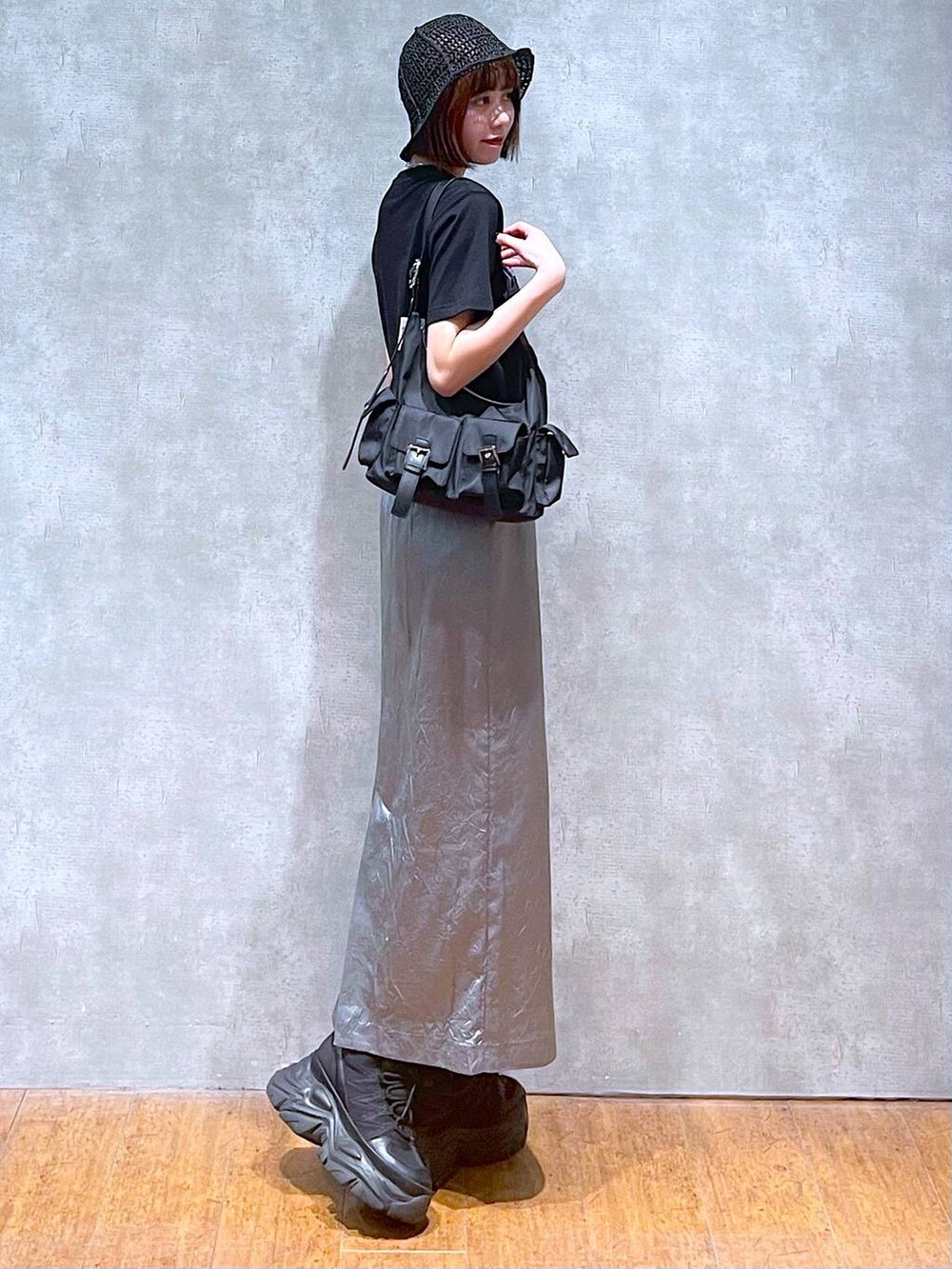 ブラック系のショルダーバッグ、ブラック系のスニーカー、ブルー系のスカートを着用したレディースの夏コーディネートの5枚目の写真