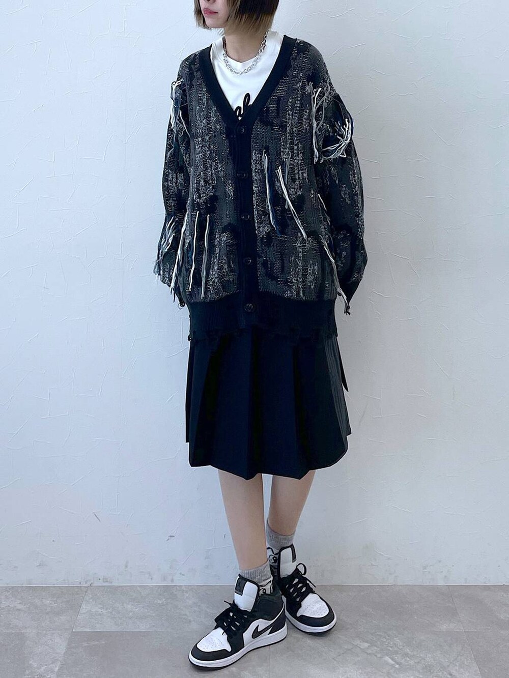 ブラック系のスラックス、ブラック系のカーディガン/ボレロ、シルバー系のネックレスを着用したレディースの冬コーディネートの3枚目の写真