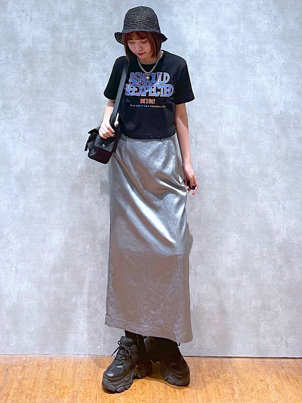 ブラック系のショルダーバッグ、ブラック系のスニーカー、ブルー系のスカートを着用したレディースの夏コーディネートの3枚目の写真