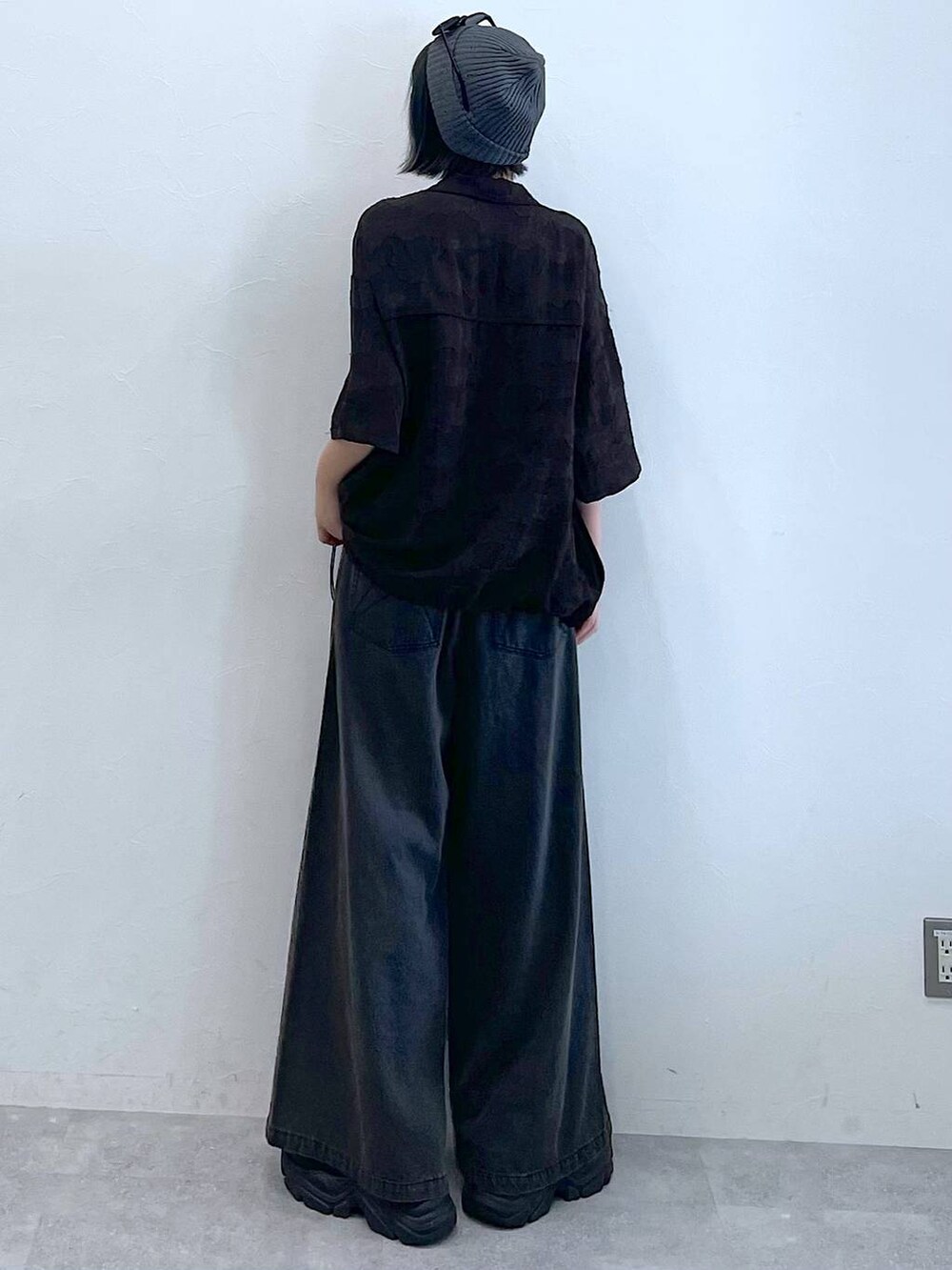 ブラック系のスニーカー、ブラック系のデニムパンツ、グレー系のシャツ/ブラウスを着用したレディースの夏コーディネートの5枚目の写真