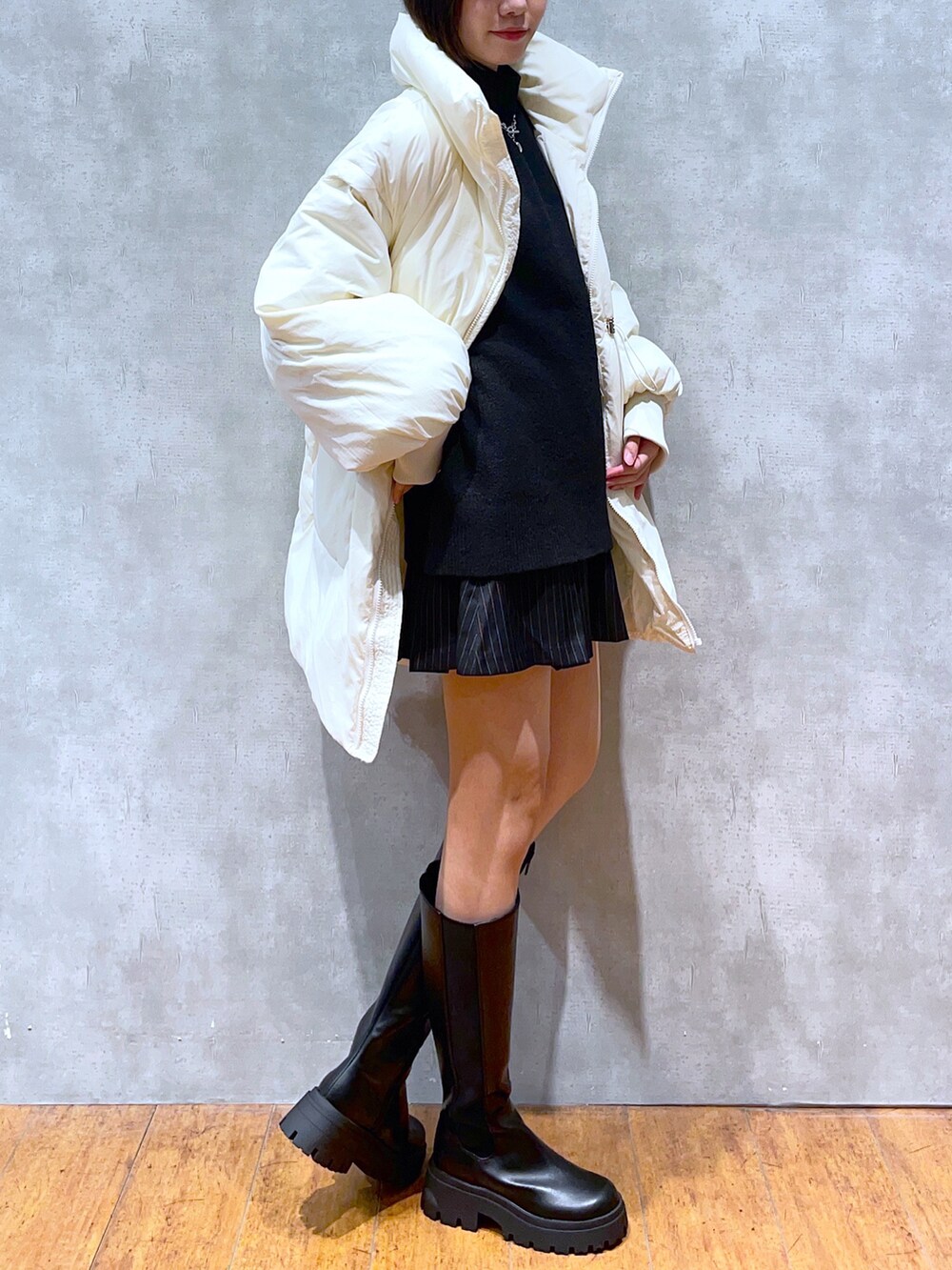 ブラック系のニット/セーター、ホワイト系のジャケット/アウター、その他のスカートを着用したレディースの秋コーディネートの2枚目の写真