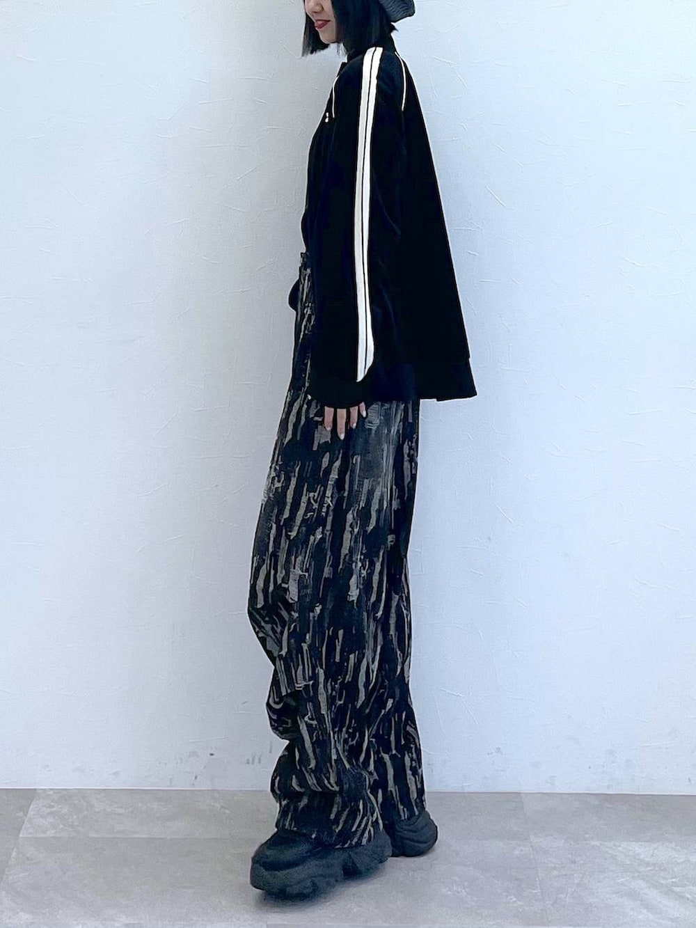 ブラック系のスニーカー、ブラック系のデニムパンツ、ブラック系のジャージを着用したレディースの秋コーディネートの2枚目の写真