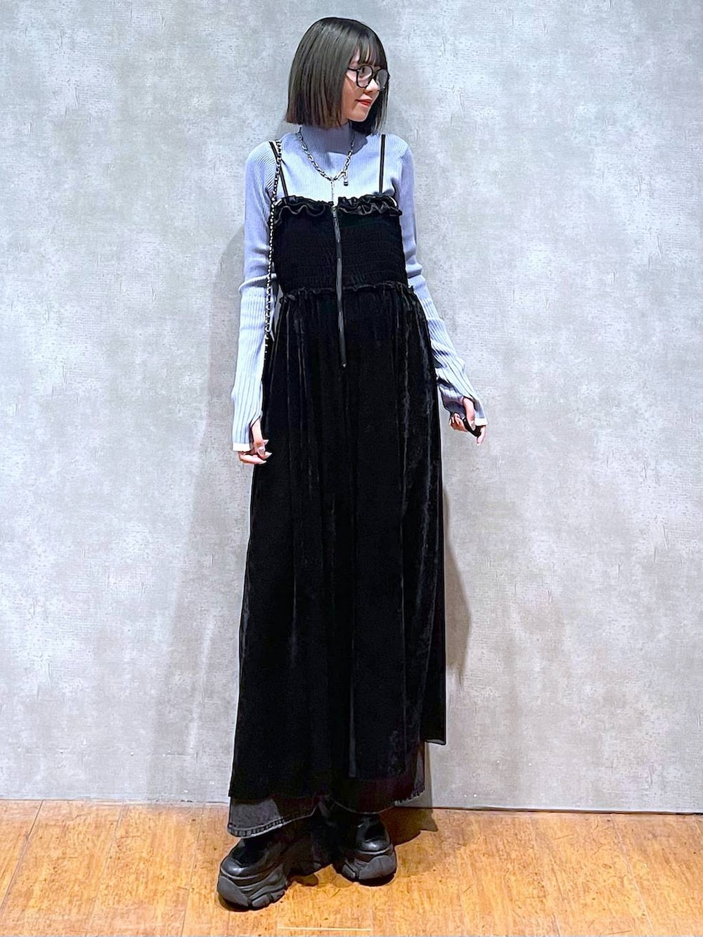 ブラック系のスニーカー、ブルー系のニット/セーター、ブラック系のデニムパンツを着用したレディースの秋コーディネートの2枚目の写真