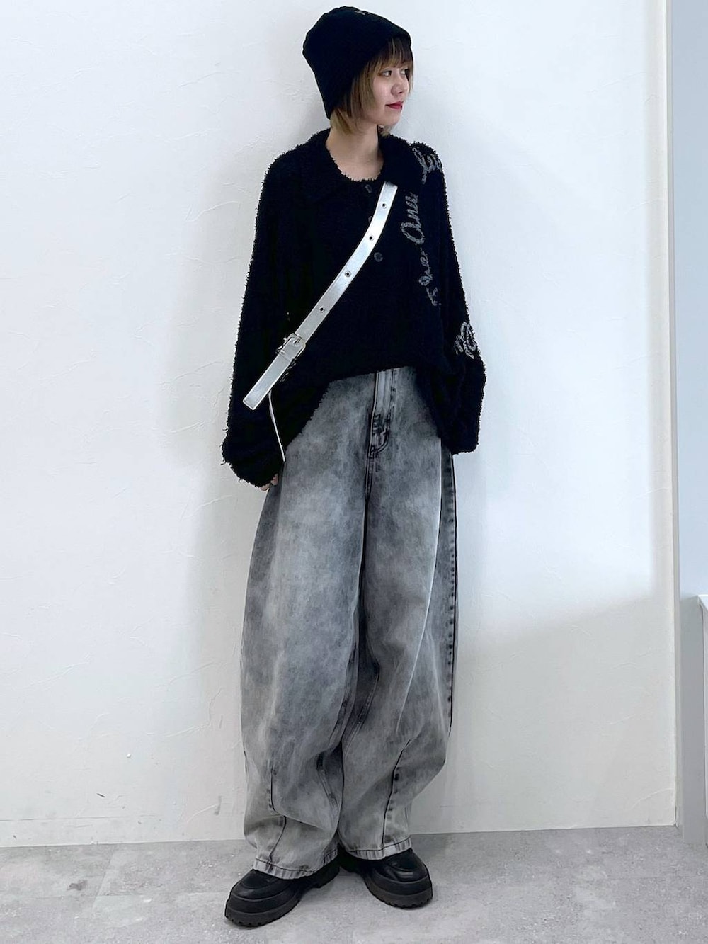 シルバー系のショルダーバッグ、ブラック系のブーツ、ブラック系のデニムパンツを着用したレディースの冬コーディネートの9枚目の写真