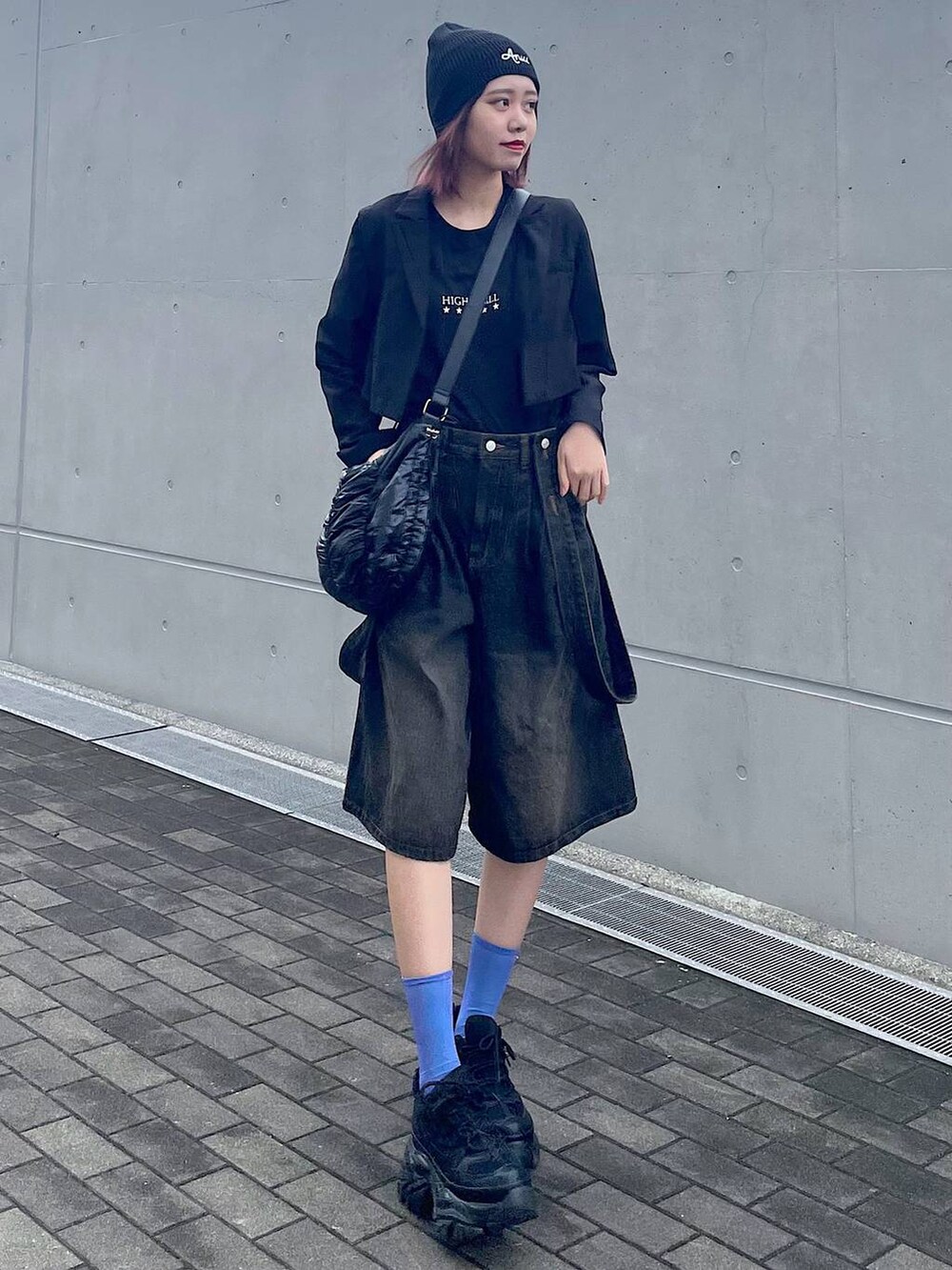 ブラック系のショルダーバッグ、ブラック系のスニーカー、ブラック系のTシャツ/カットソーを着用したレディースの春コーディネートの4枚目の写真