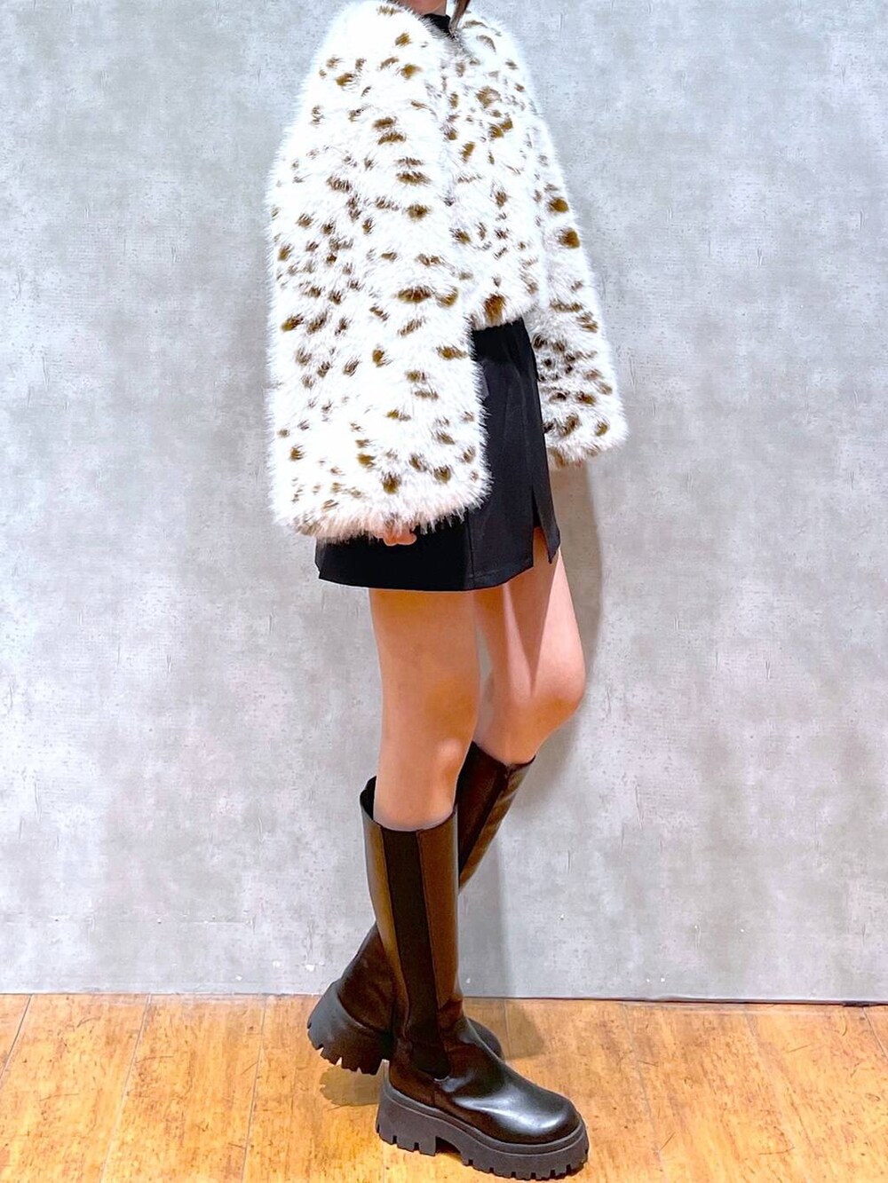 ブラック系のブーツ、ブラック系のニット/セーター、ブラウン系のブルゾンを着用したレディースの冬コーディネートの5枚目の写真