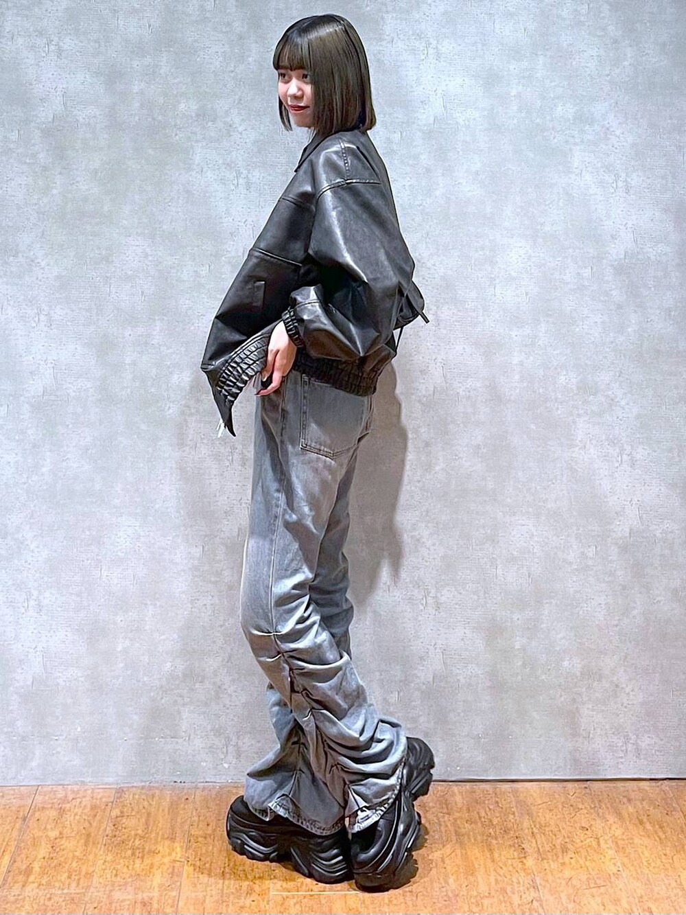 ブラック系のスニーカー、ブラック系のショルダーバッグ、ブルー系のデニムパンツを着用したレディースの秋コーディネートの10枚目の写真