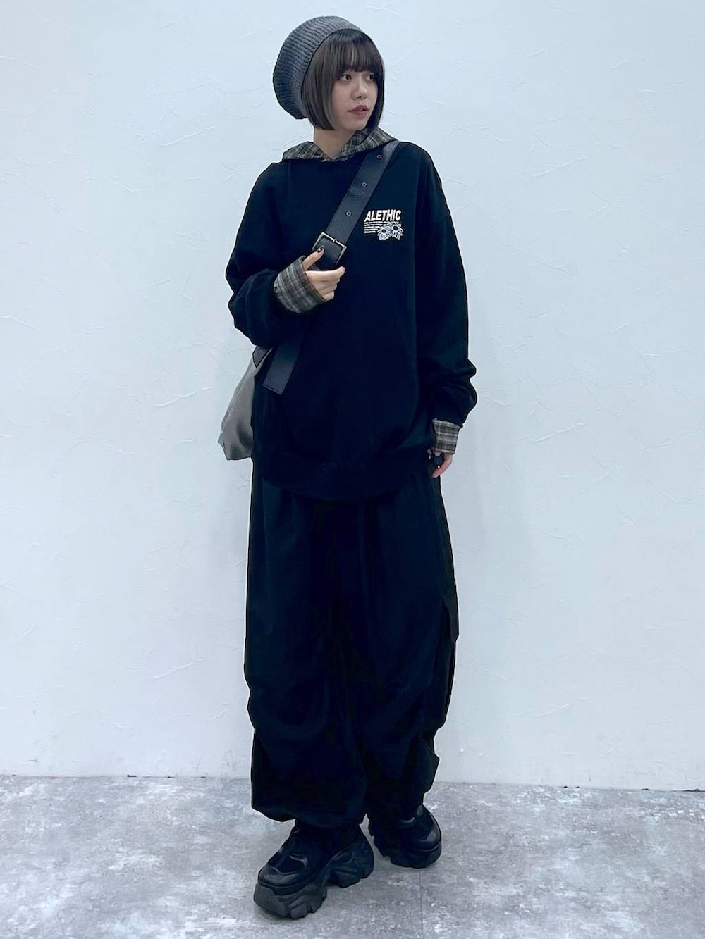 ブラック系のスニーカー、ブラック系のスウェット、シルバー系のトートバッグを着用したレディースの秋コーディネートの3枚目の写真