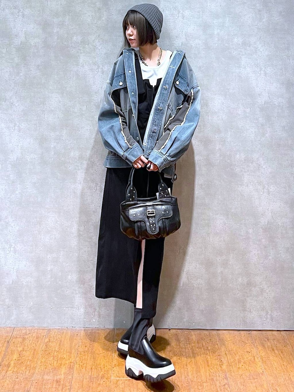 ブルー系のブルゾン、ブラック系のハンドバッグ、ホワイト系のTシャツ/カットソーを着用したレディースの秋コーディネートの8枚目の写真