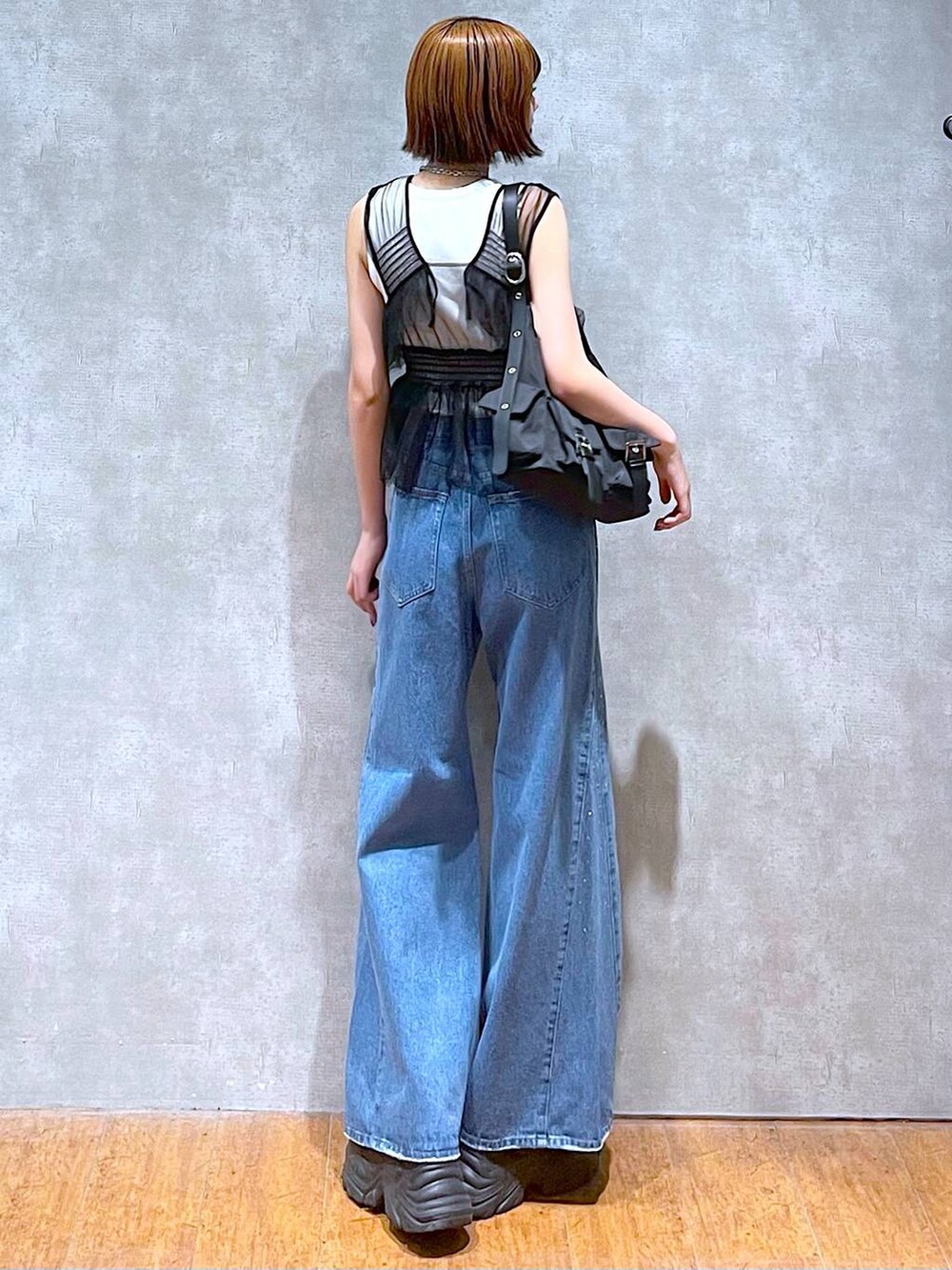 ブラック系のショルダーバッグ、ブラック系のスニーカー、ブラック系のベストを着用したレディースの夏コーディネートの4枚目の写真