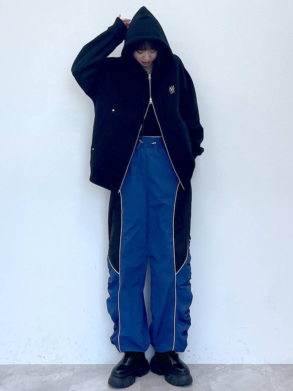 ブラック系のパーカー、ブラック系のブーツ、ブルー系のその他パンツを着用したレディースの冬コーディネートの3枚目の写真