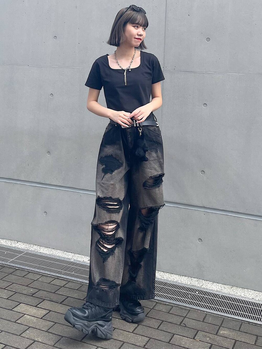 ブラック系のスニーカー、ブラック系のデニムパンツ、ブラック系のTシャツ/カットソーを着用したレディースの夏コーディネートの3枚目の写真