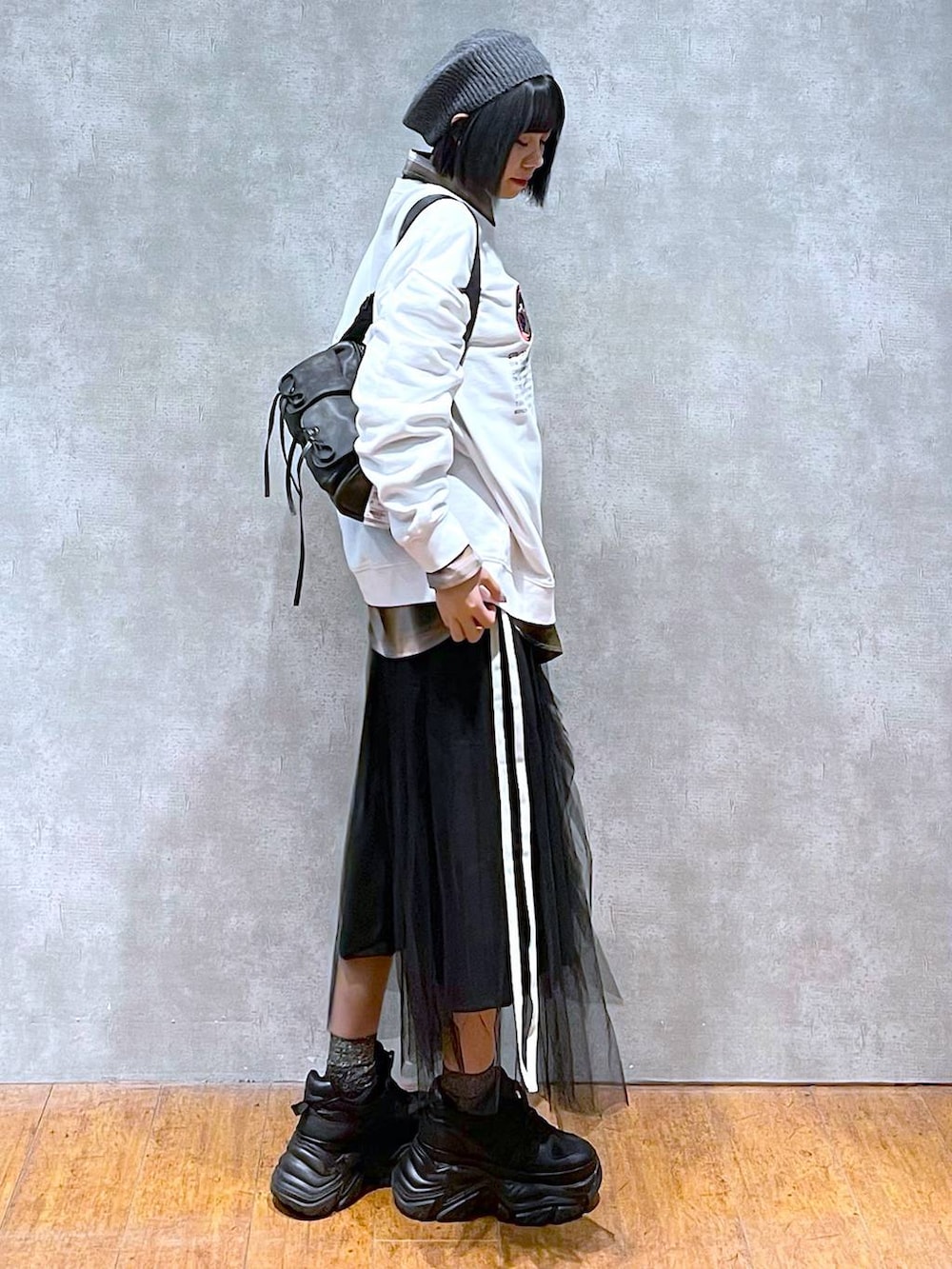 ブラック系のスニーカー、ブラック系のショルダーバッグ、ブラック系のスカートを着用したレディースの秋コーディネートの5枚目の写真